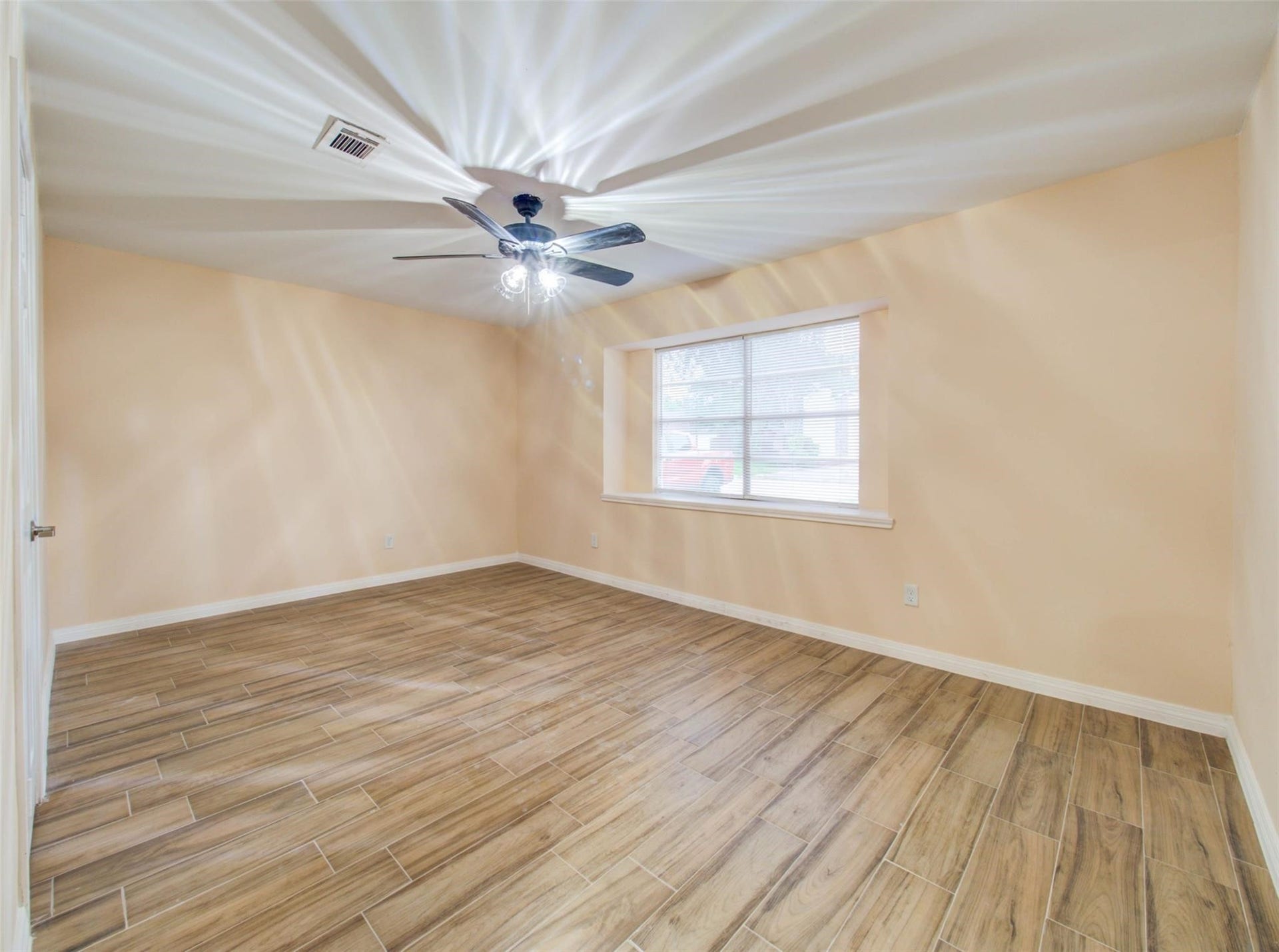 13526 Sherwood Street, Sugar Land, TX 77498 Bright, spacious room, a ceiling fan, and a large window for natural light. Neutral wall colors enhance the airy feel.