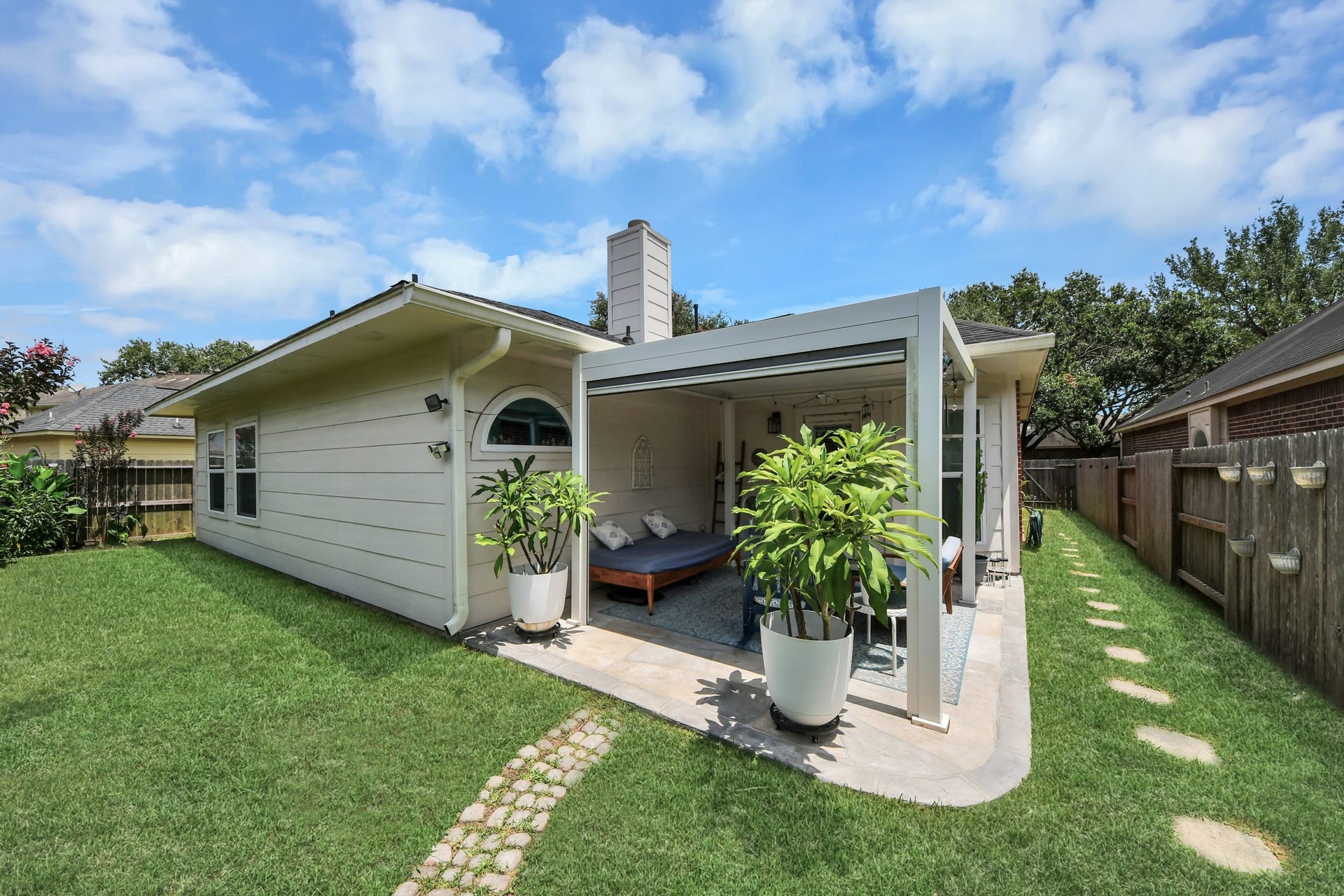 A view from the backyard showing the size of the covered patio and surrounding lawn.