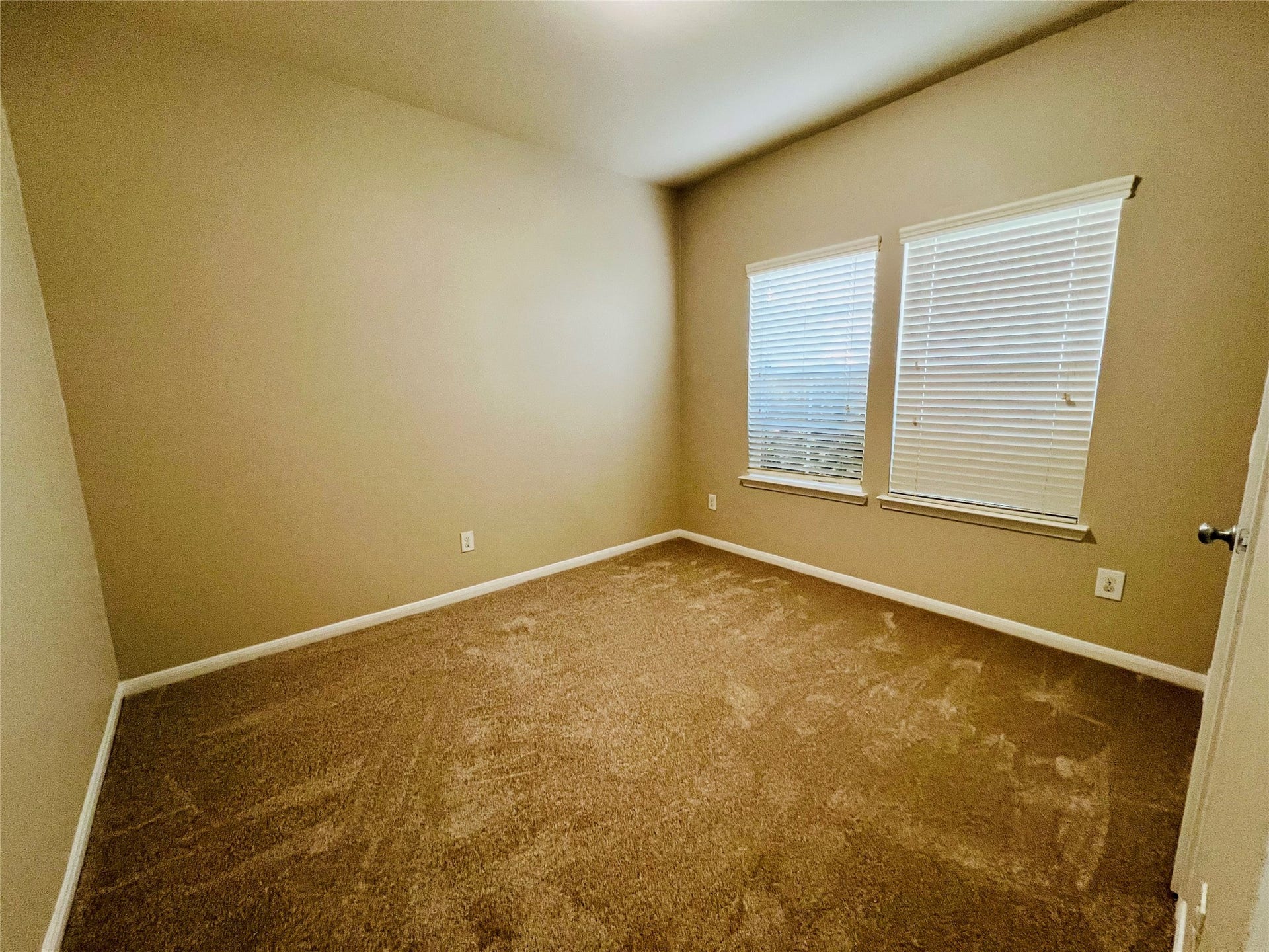 1721 Claremont Garden Circle, Houston, TX 77047 Cozy bedroom with soft carpeting and natural light streaming through dual windows, creating a warm and inviting atmosphere.