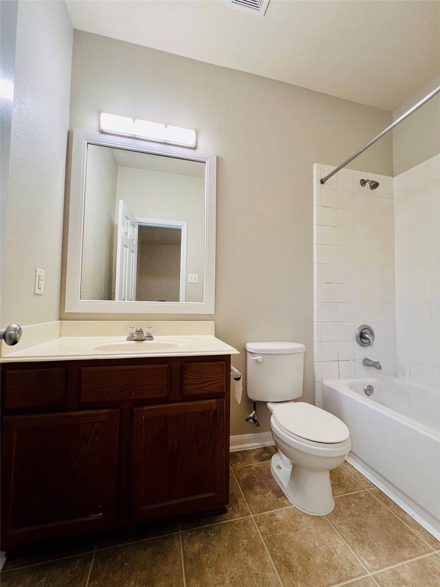 1721 Claremont Garden Circle, Houston, TX 77047 Bright bathroom featuring a sleek vanity with ample storage, a modern mirror with integrated lighting, and a classic shower-tub combo with white tile surround.