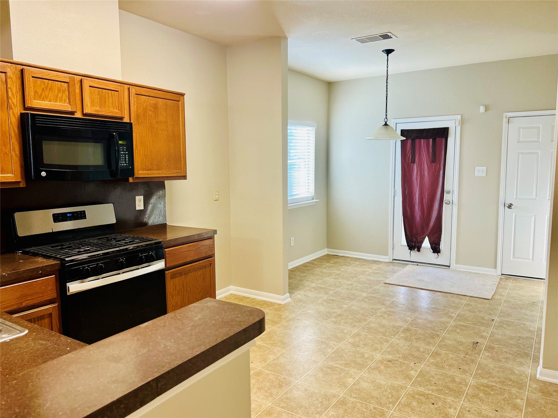 1721 Claremont Garden Circle, Houston, TX 77047 Bright kitchen and dining area with warm wood cabinetry, modern appliances, and a cozy nook leading to the backyard.