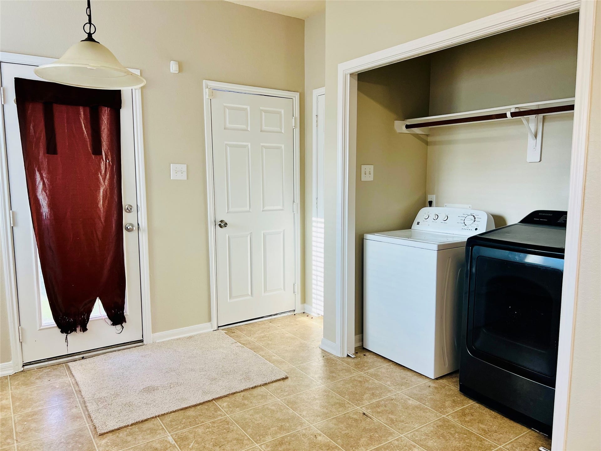 1721 Claremont Garden Circle, Houston, TX 77047 Bright and functional laundry room with modern washer and dryer, convenient shelving, and access to the outdoors.
