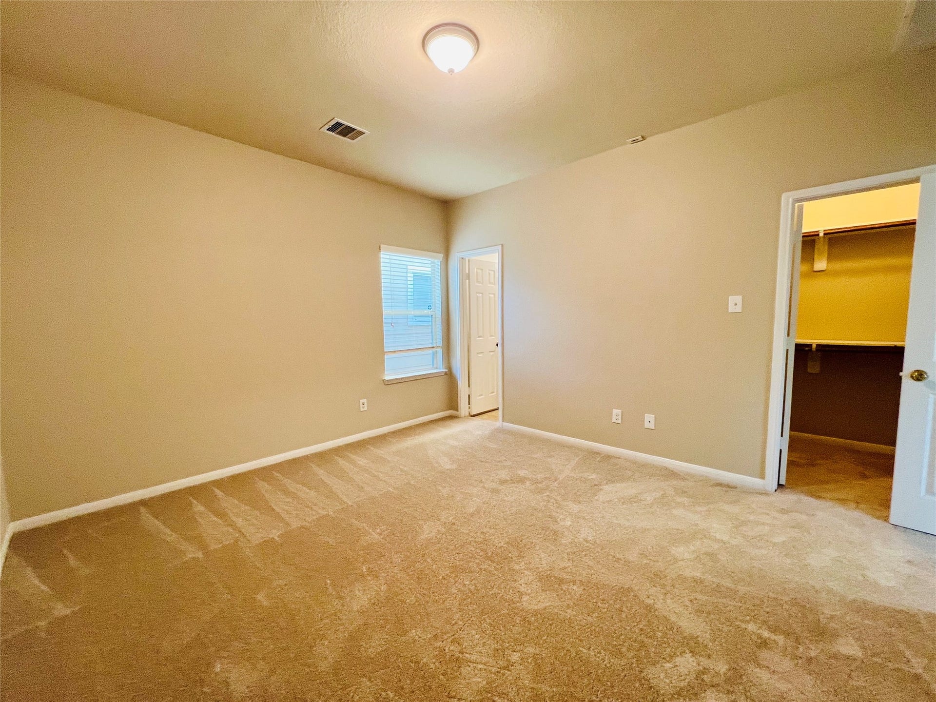1721 Claremont Garden Circle, Houston, TX 77047 Spacious bedroom with plush carpeting, neutral walls, and ample natural light, featuring a convenient walk-in closet.