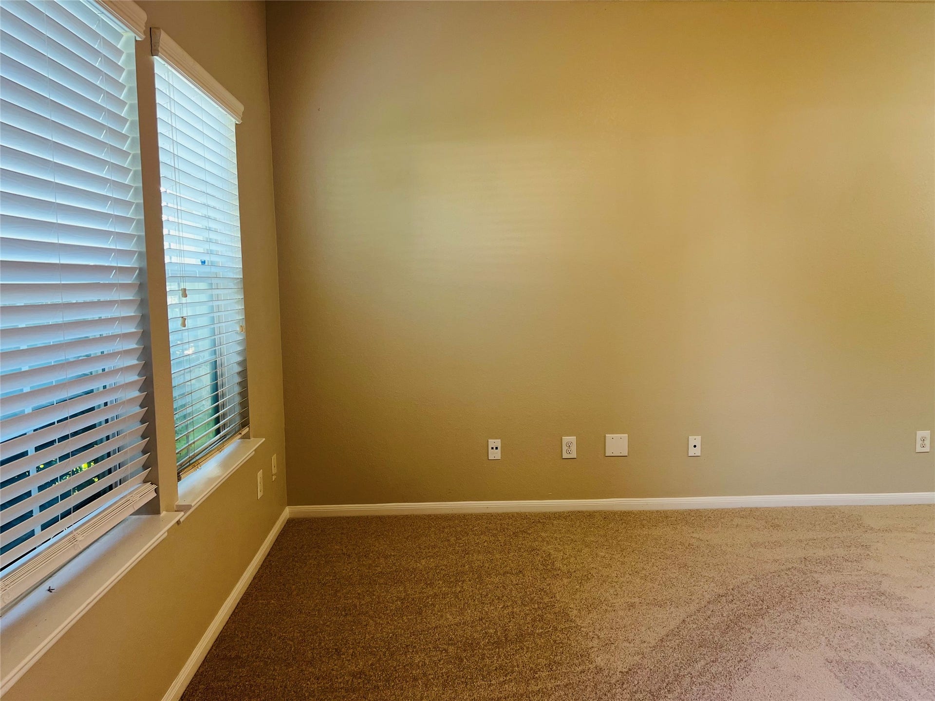 1721 Claremont Garden Circle, Houston, TX 77047 Bright room with neutral walls and soft carpeting, featuring large windows adorned with blinds for ample natural light. Perfect for a cozy retreat or versatile workspace.