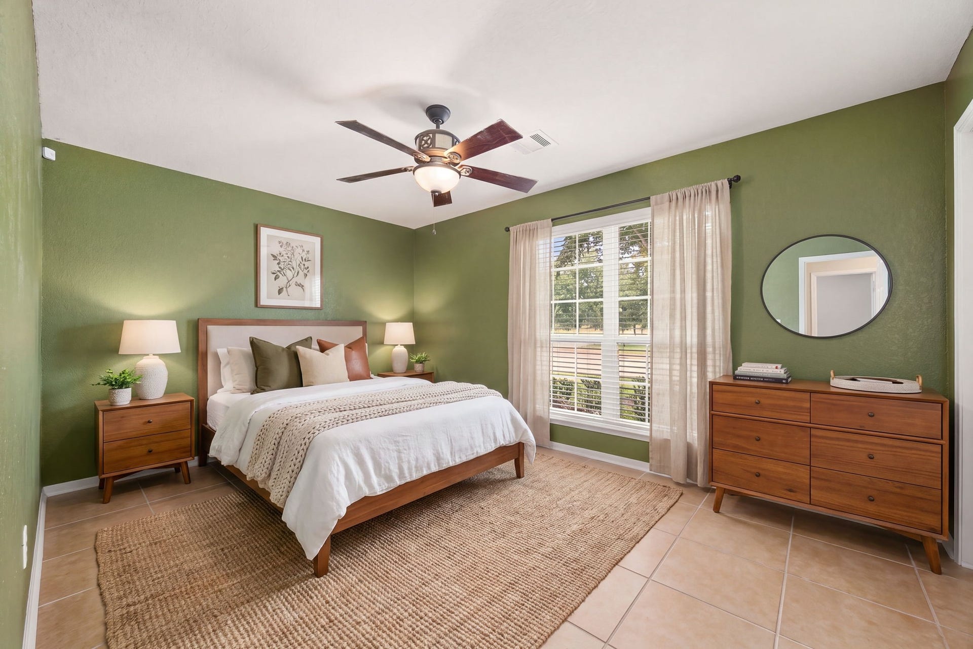 Bright secondary bedroom located at the front of the home, featuring a large window that fills the space with abundant natural light and a central ceiling fan for year-round comfort. The inviting layout offers durable tile flooring and flexible proportions, providing a welcoming retreat perfect for family members or overnight guests. *Virtually Staged