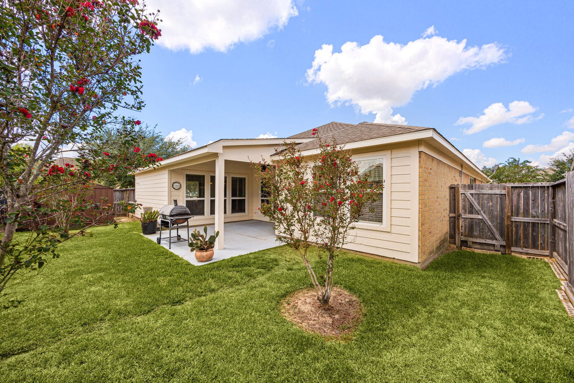 Another great view of the fully fenced backyard, highlighting the lush green lawn and mature landscaping.