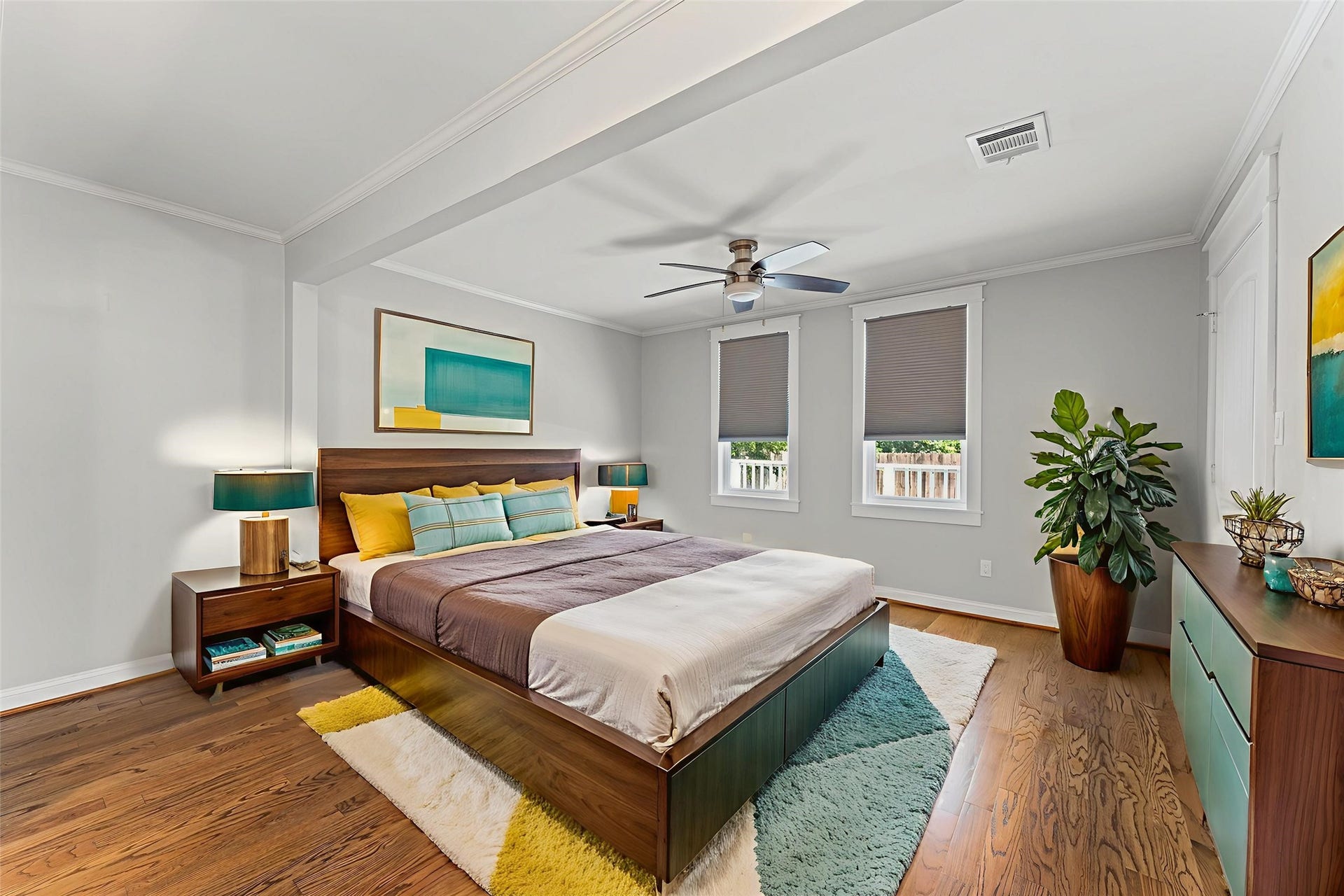 1204 Shearn Street, Houston, TX 77007 This bedroom features a modern design with hardwood floors. It has a ceiling fan, two windows with shades add to the cozy atmosphere.
