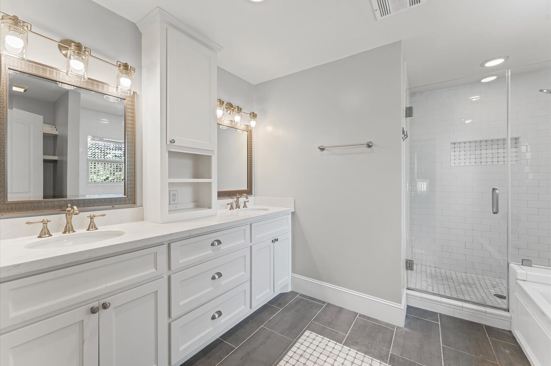 1204 Shearn Street, Houston, TX 77007 This bright and modern bathroom features dual sinks with elegant fixtures, ample cabinetry, a spacious walk-in shower with subway tile, and stylish lighting.