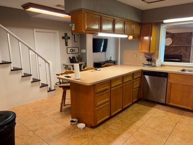 1909 11th Avenue, La Marque, TX 77568 As you enter the front door the kitchen is just to your right. The door near the stairs goes to the garage and the stairs go to the Primary Bedroom.