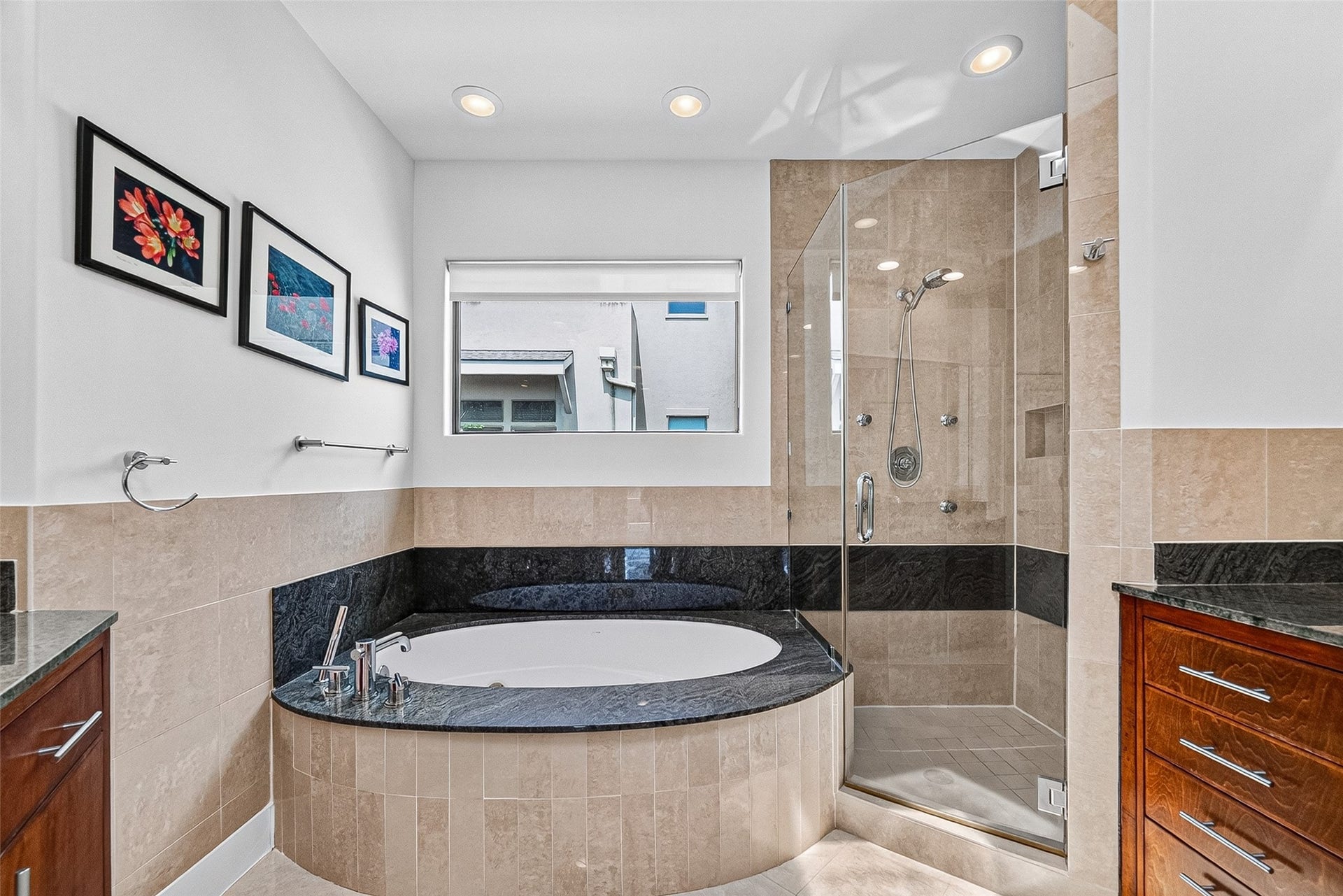 1110 Autrey Street, #C, Houston, TX 77006 Luxurious primary bathroom featuring a spa-like soaking tub with elegant black trim, a spacious glass-enclosed shower, and stylish wood cabinetry, all complemented by modern recessed lighting and tasteful artwork.