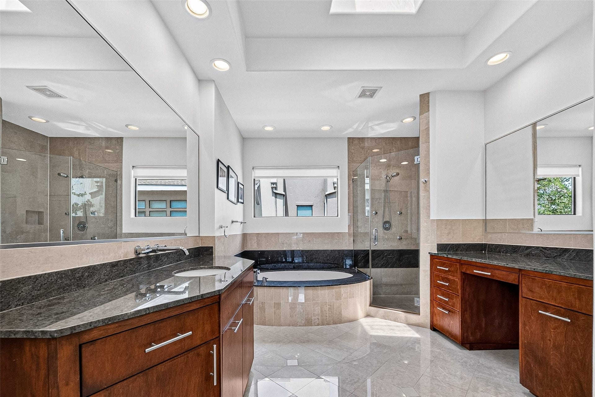 1110 Autrey Street, #C, Houston, TX 77006 Luxurious primary bathroom featuring a spacious soaking tub, elegant granite countertops, wood cabinetry, and a glass-enclosed shower, all illuminated by natural light.