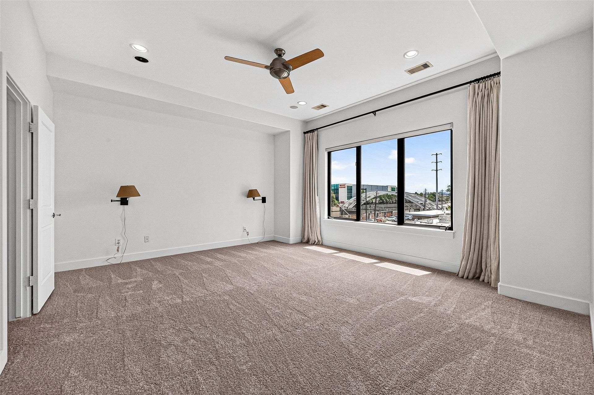 1110 Autrey Street, #C, Houston, TX 77006 Spacious primary bedroom with plush carpeting, large window offering ample natural light, perfect for relaxation.