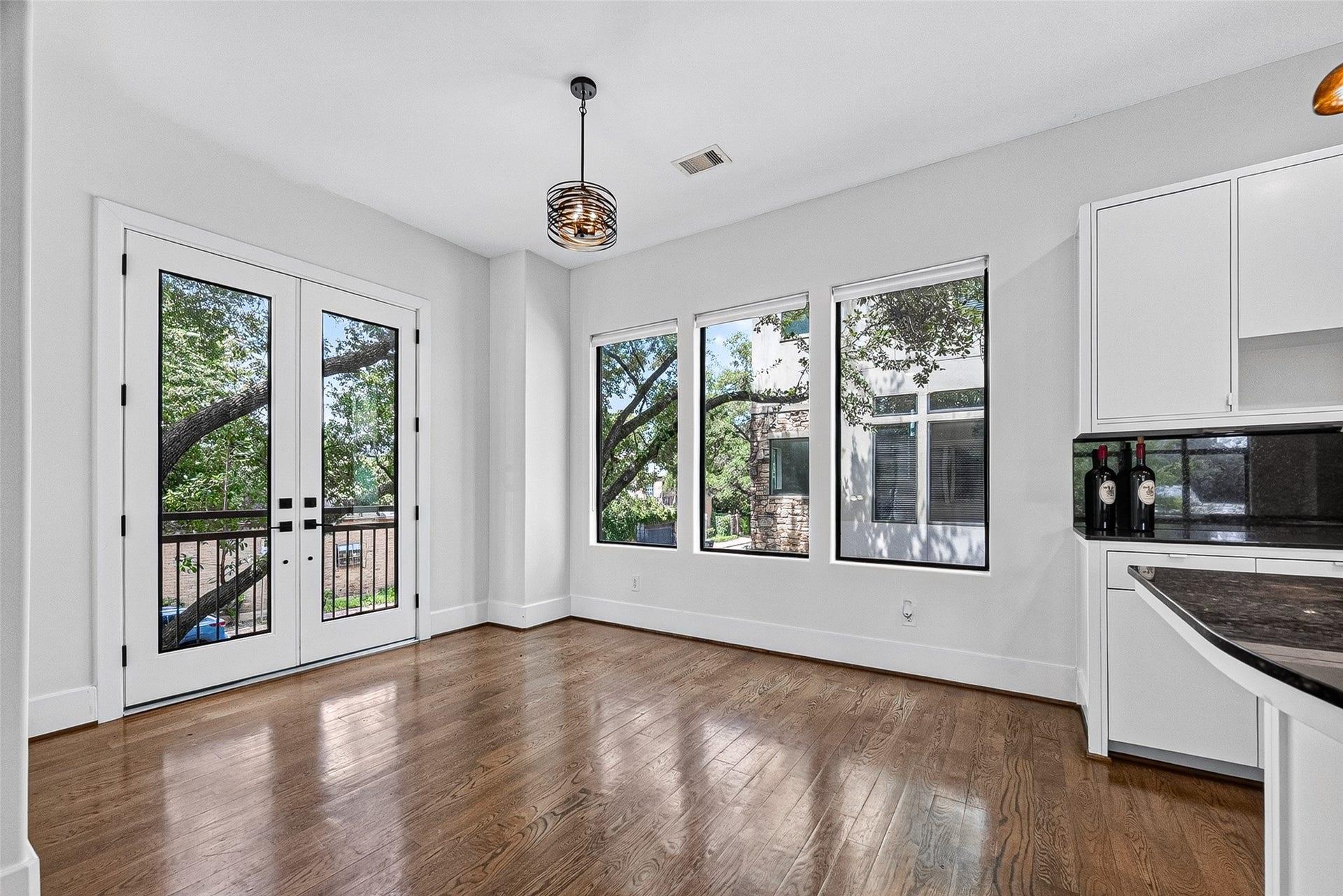 1110 Autrey Street, #C, Houston, TX 77006 Bright breakfast area with elegant hardwood floors, large windows offering scenic views, and stylish French doors leading to a patio.