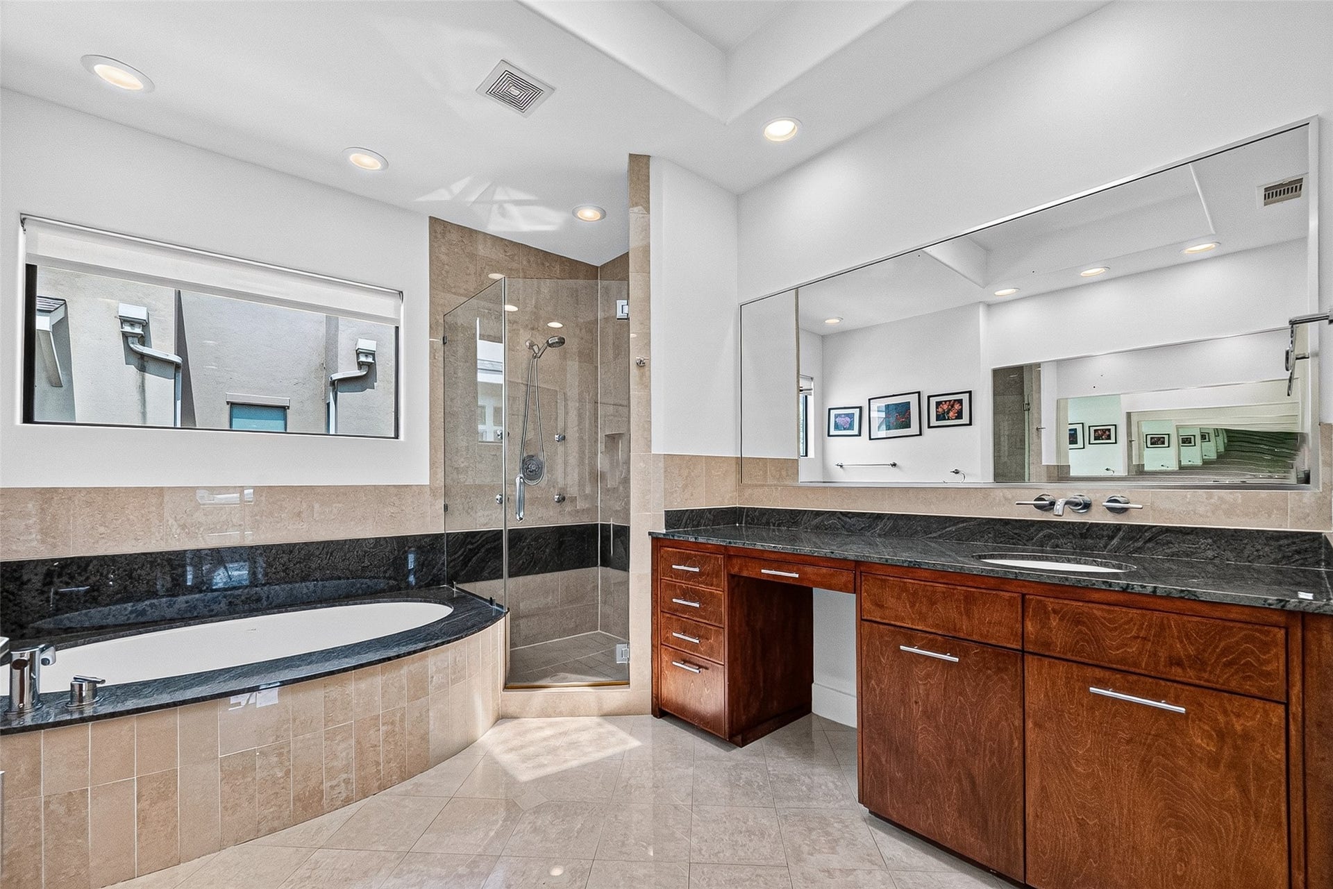 1110 Autrey Street, #C, Houston, TX 77006 Luxurious primary bathroom featuring a spacious glass-enclosed shower, elegant soaking tub, and sleek vanity with rich wood cabinetry and black granite countertops.
