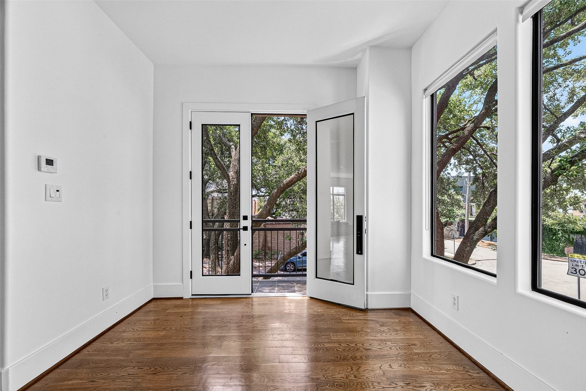 1110 Autrey Street, #C, Houston, TX 77006 Bright and inviting breakfast area featuring large windows and French doors leading to a charming balcony, perfect for enjoying natural light and outdoor views.