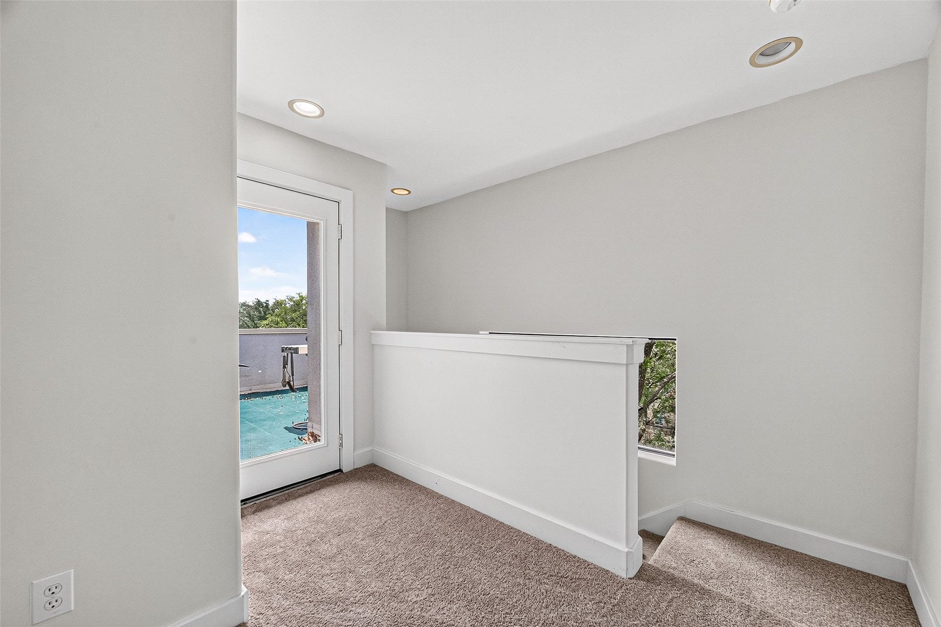 1110 Autrey Street, #C, Houston, TX 77006 Bright and airy landing area on fourth floor with plush carpeting, recessed lighting, and a door leading to a scenic balcony view.