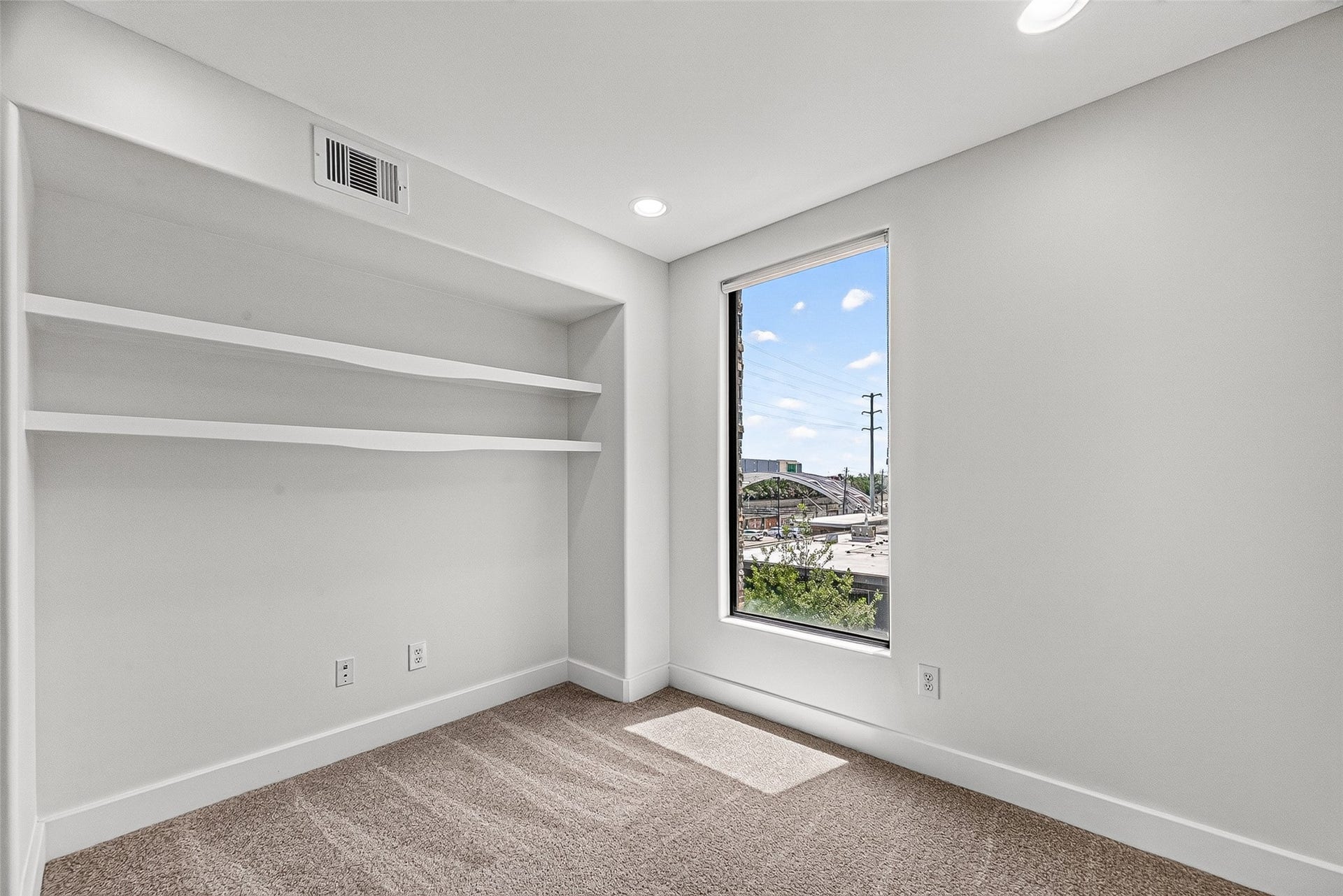 1110 Autrey Street, #C, Houston, TX 77006 Bright and cozy flex room with built-in shelves, plush carpeting, and large windows offering city views.
