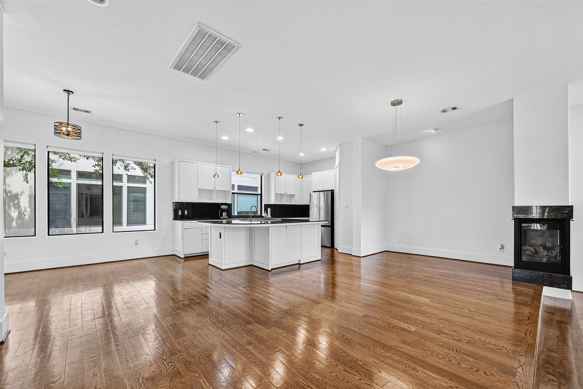 1110 Autrey Street, #C, Houston, TX 77006 Spacious open-concept living area features sleek hardwood floors, a modern kitchen with a large island, stainless steel appliances, and abundant natural light from large windows.