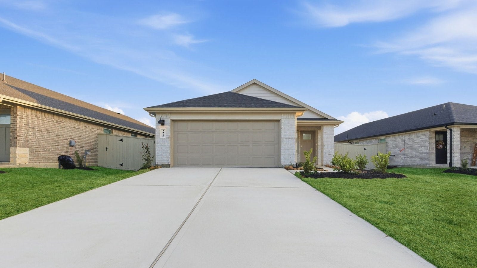 Newly built single story home with traditional architecture, a double garage, and landscaped front yard.
