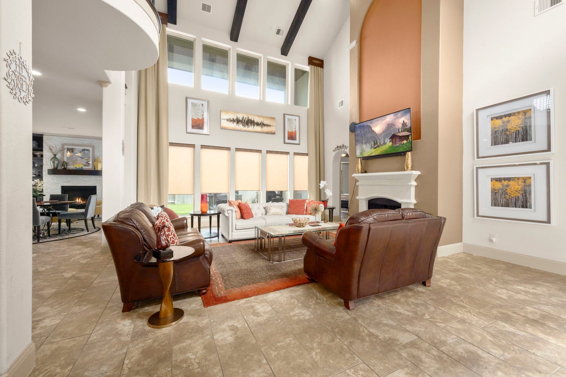 5103 Jackson Ponds Court, Sugar Land, TX 77479 This spacious living room features high ceilings, large windows with abundant natural light, and a central fireplace. The open layout connects to the kitchen area, enhancing the sense of space.