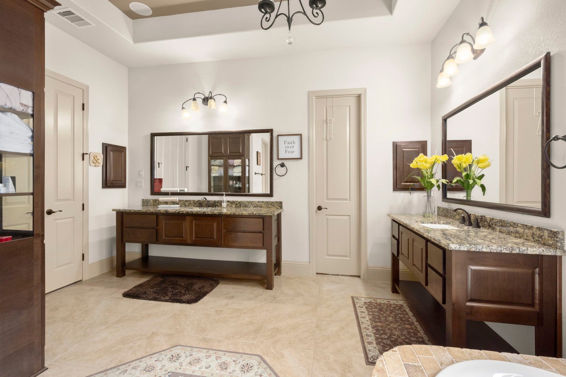 5103 Jackson Ponds Court, Sugar Land, TX 77479 This spacious bathroom features dual vanities with granite countertops, elegant lighting fixtures, and ample cabinet storage. It also features a shower, tub and two walk-in closets.