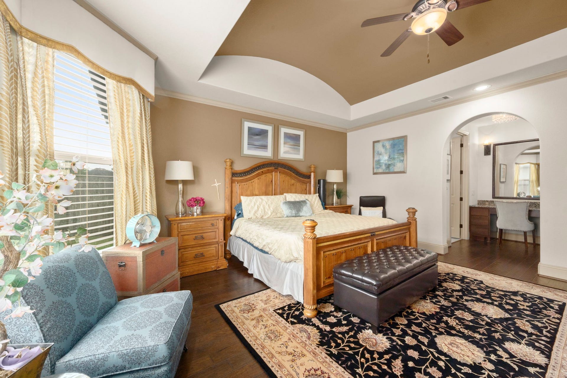 5103 Jackson Ponds Court, Sugar Land, TX 77479 This spacious primary bedroom connects to a well-appointed ensuite bathroom through an arched doorway.