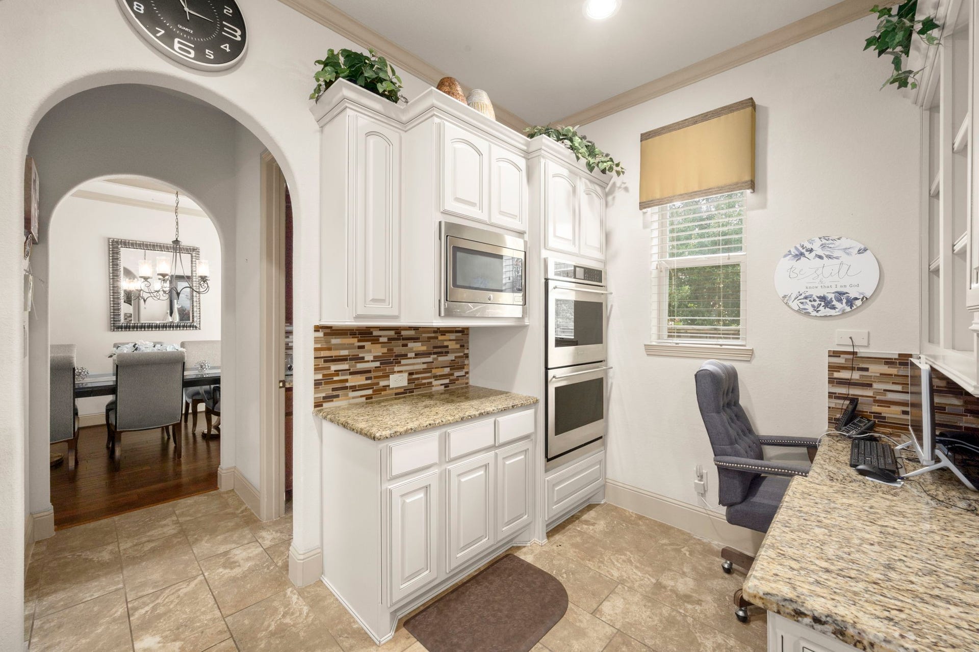 5103 Jackson Ponds Court, Sugar Land, TX 77479 This area of the kitchen features a cozy workspace and an arched walkway that leads to a dining room, walk-in pantry and secondary kitchenette.