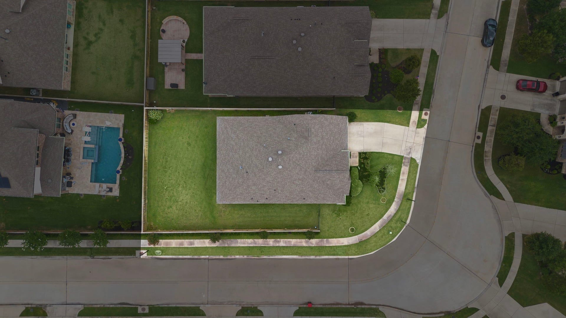 31. This overhead aerial view clearly illustrates the property layout, including the home, driveway, landscaped front yard, expansive fenced backyard, and corner-oriented lot configuration. The birds-eye perspective emphasizes the generous outdoor space and provides a useful look at how the property is positioned within the surrounding streetscape.