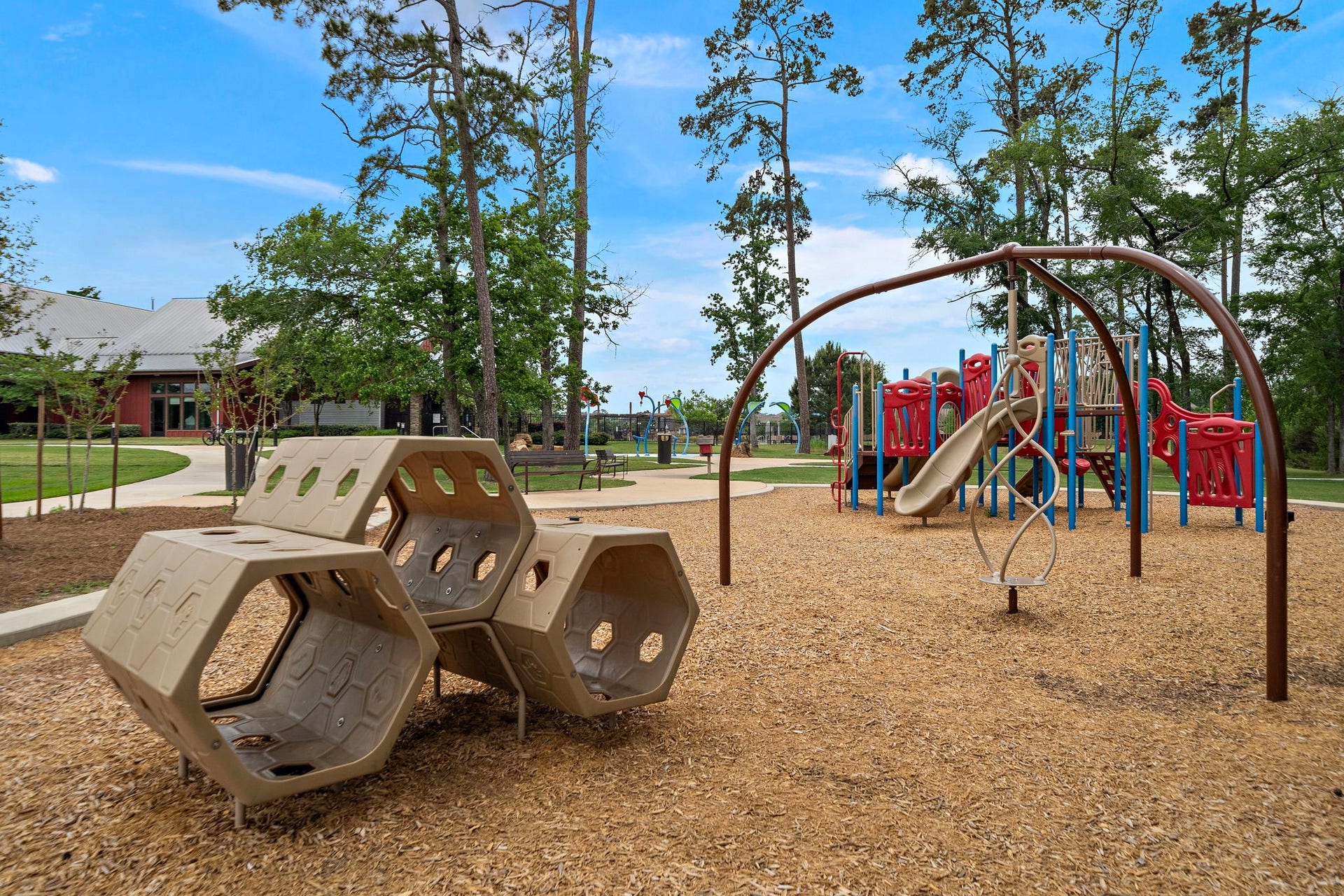 The neighborhood playground offers a colorful, inviting outdoor space with climbing structures, slides, swings, open lawn, shaded trees, and nearby walking paths. Designed for recreation and outdoor enjoyment, this community amenity provides a convenient setting for play, fresh air, and time spent outside within the beautifully maintained neighborhood.