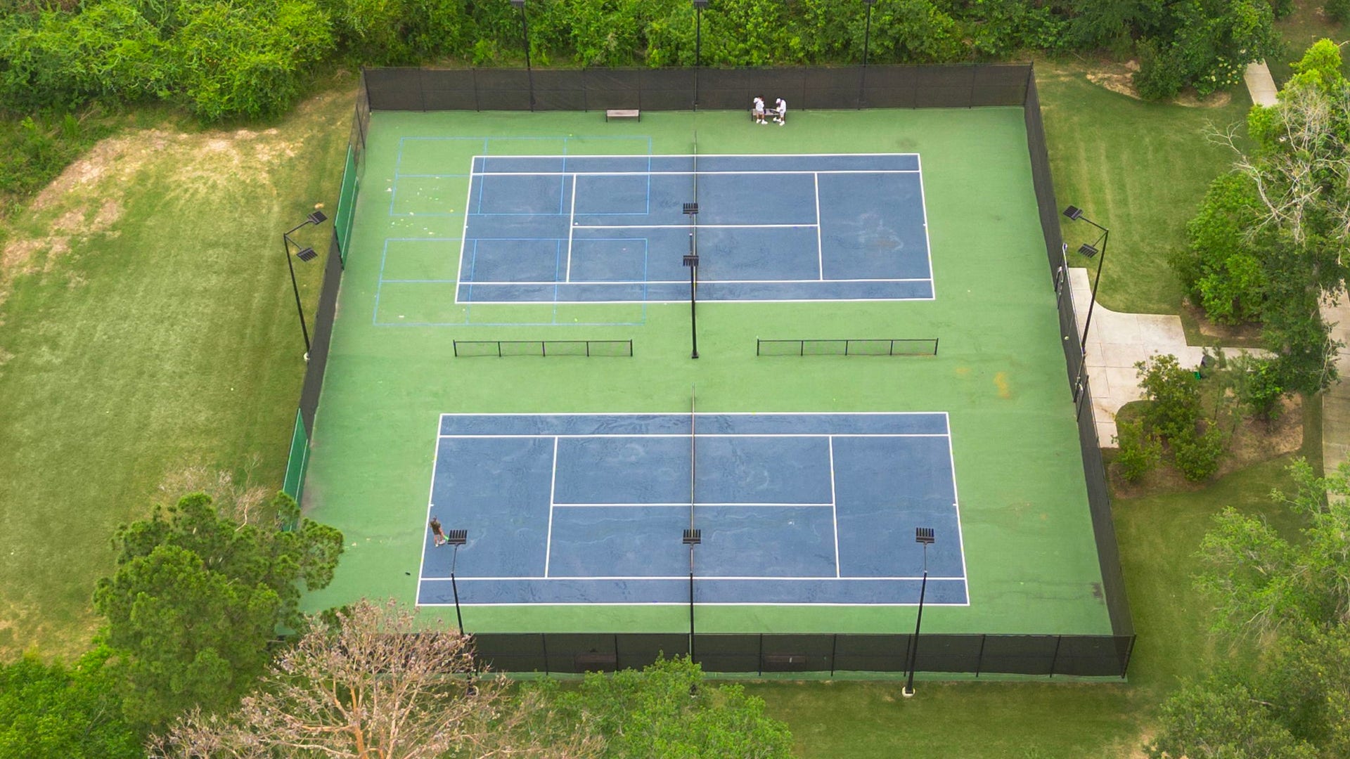 Community tennis courts provide another outstanding recreational option, offering multiple fenced and lighted courts surrounded by mature trees and landscaped green space. Whether enjoying a casual match or regular practice, residents have convenient access to outdoor recreation as part of the neighborhoods extensive collection of amenities.
