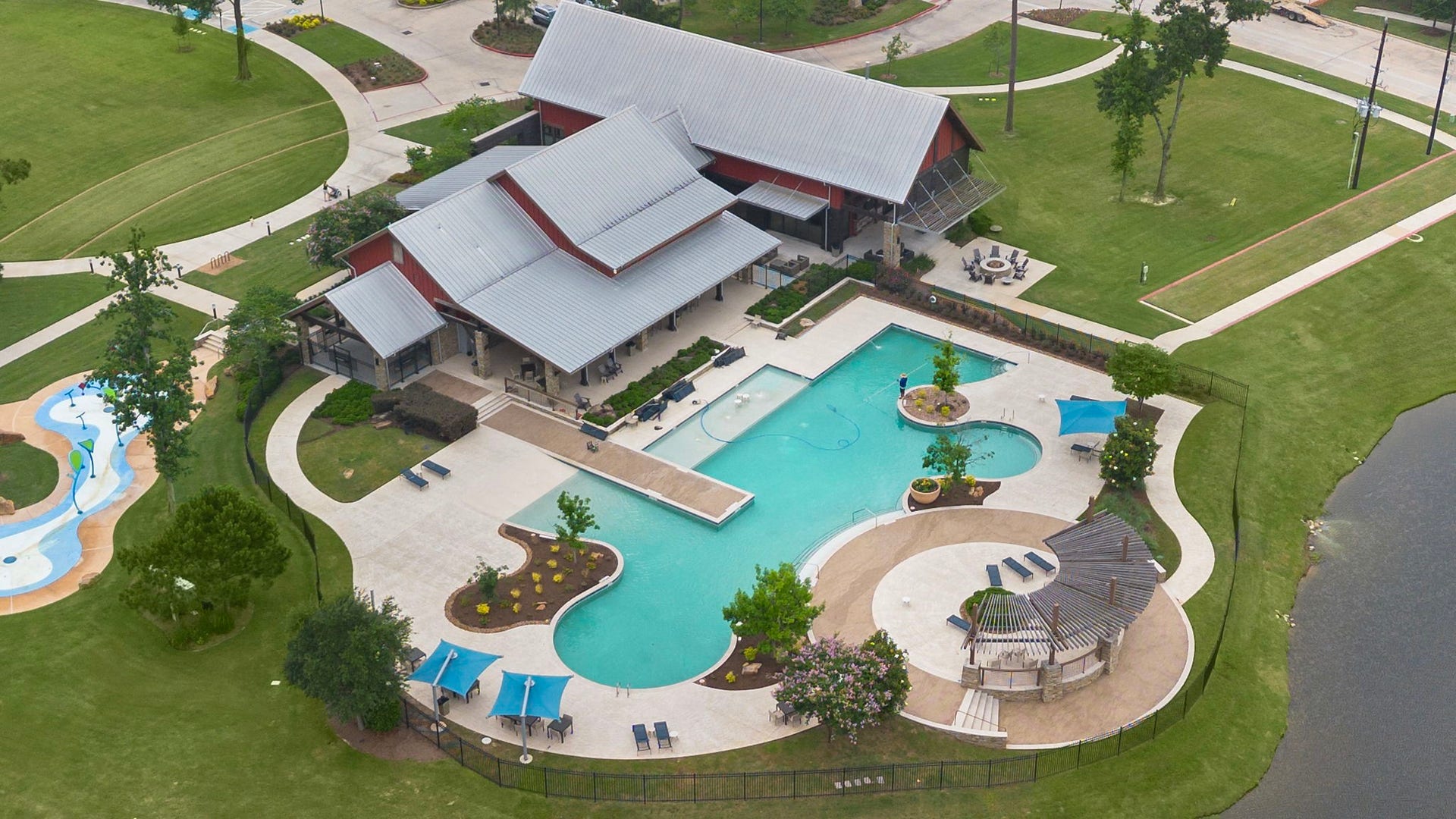 The resort-style community pool area provides an inviting destination for relaxation and recreation, featuring expansive swimming areas, generous poolside decking, shaded seating, landscaped surroundings, and an attractive clubhouse nearby. Walking paths and surrounding green space enhance this thoughtfully designed neighborhood amenity.
