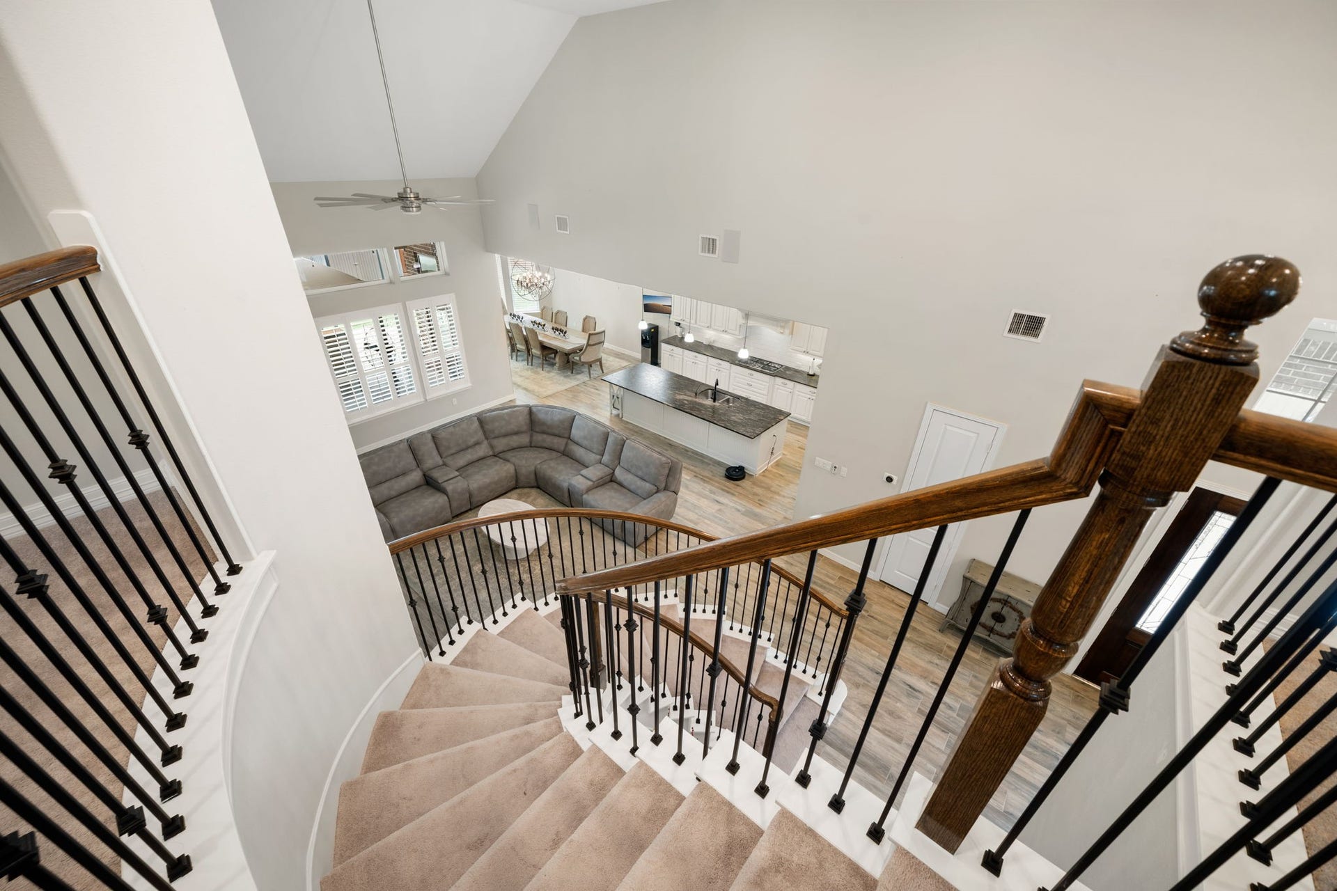 Let's head upstairs  the curved staircase with wrought-iron balusters overlooks the family room and kitchen below, connecting the home's two levels.