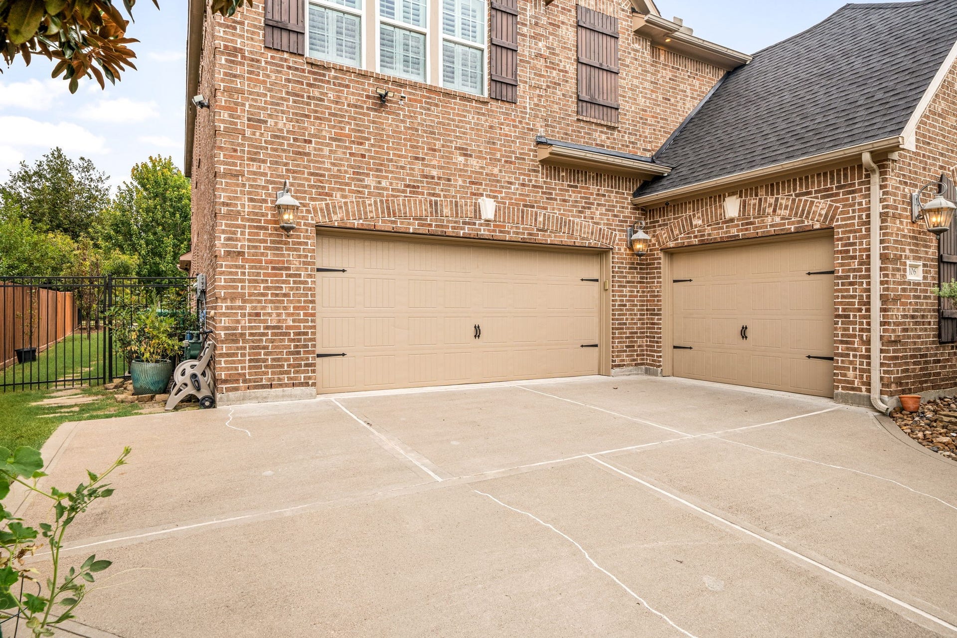 The three-car garage offers ample space for vehicles and storage, with a double-wide driveway for additional parking.