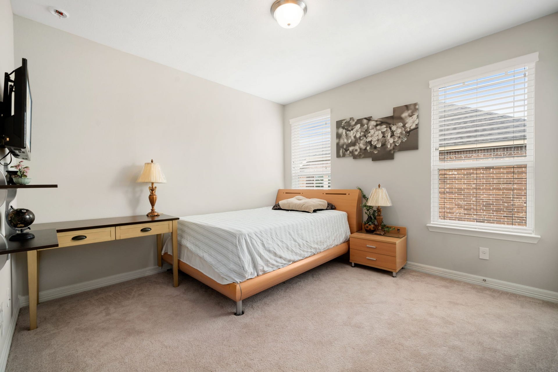 A bright secondary bedroom upstairs offers plush carpet and large windows with natural light.