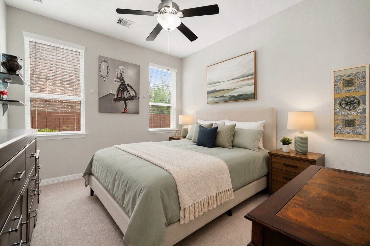 This secondary bedroom, located downstairs with its own private bath, offers a comfortable retreat with plush carpet and ceiling fan. Virtually staged.