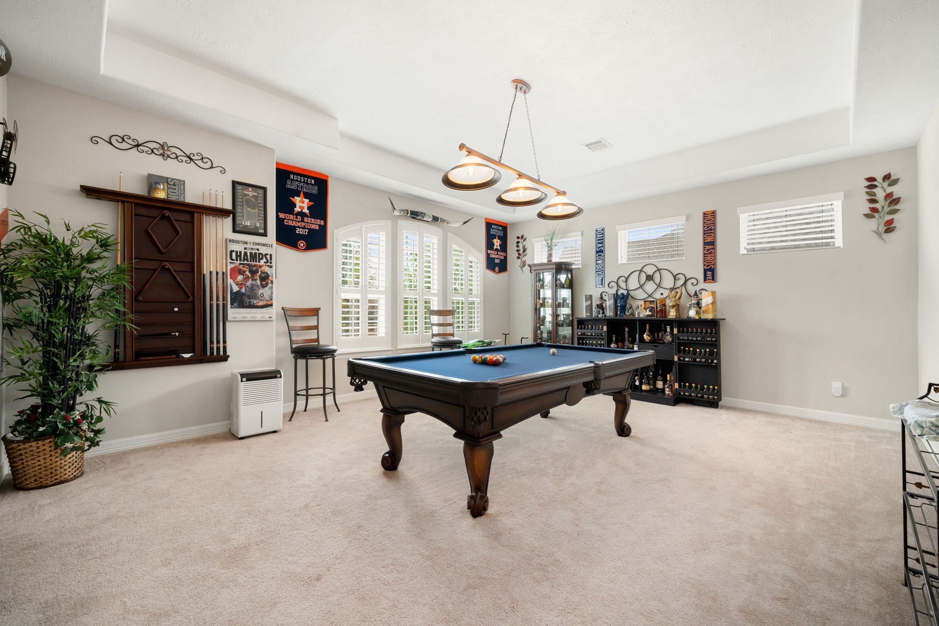 The spacious upstairs gameroom offers plenty of room for a pool table and entertaining, finished with plush carpet and natural light from arched windows.