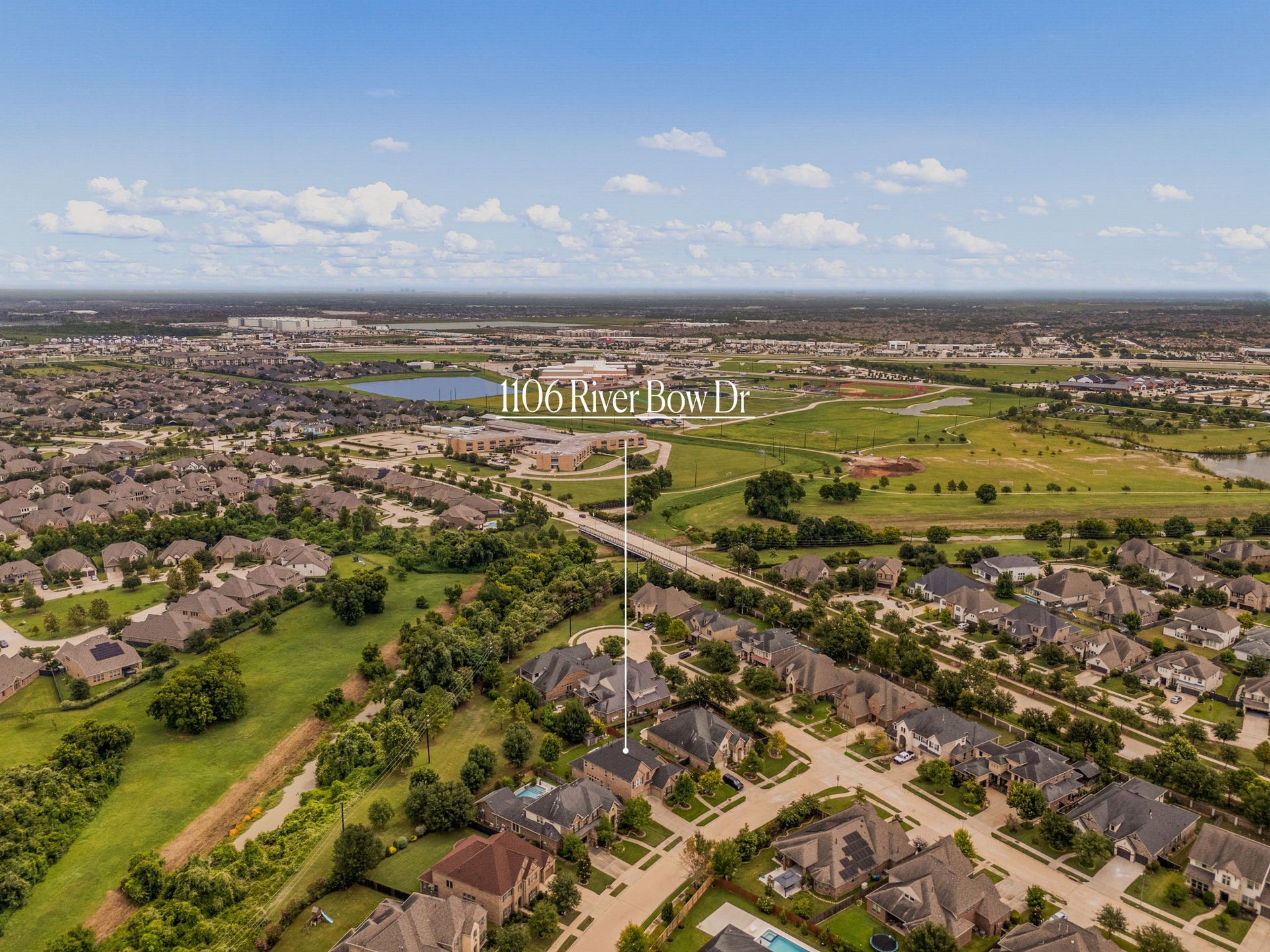 A wider aerial view showing 1106 River Bow Drive's location within Harvest Green, close to the community's parks and green space.