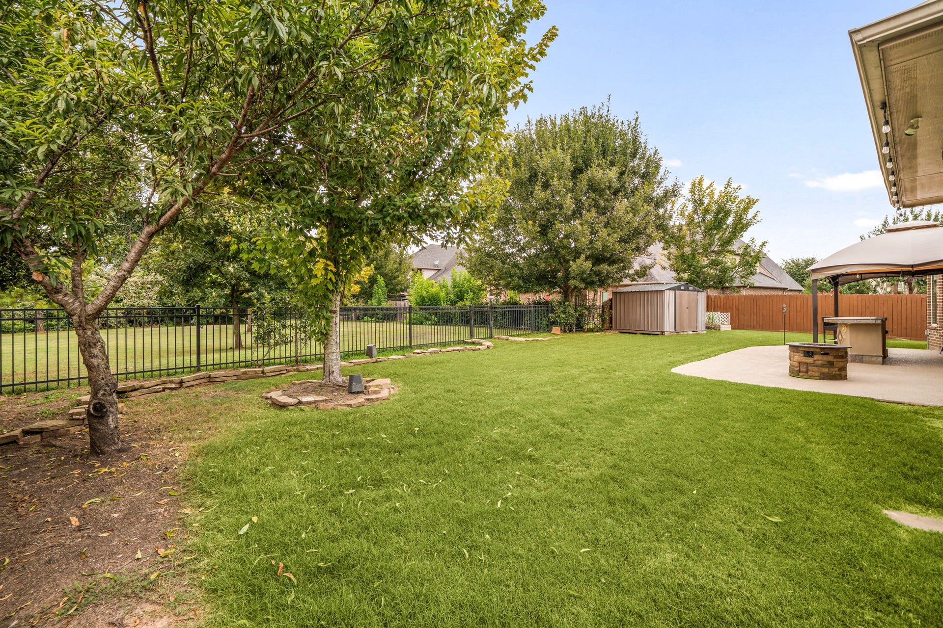 The backyard offers a large, fully fenced lawn with mature trees and a storage shed, plenty of room to enjoy the outdoors.