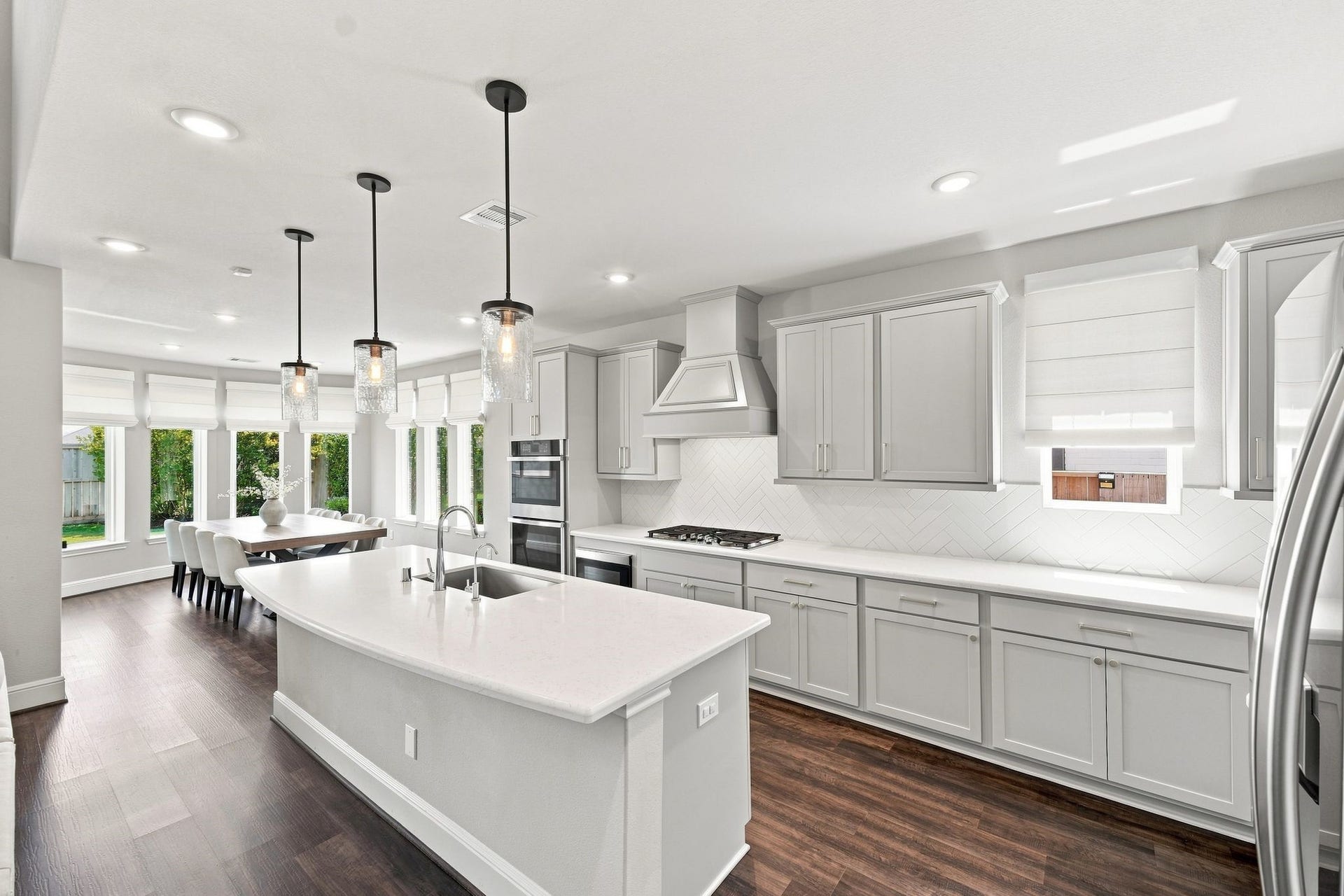 3011 Lantana Trail, Katy, TX 77493 The open-concept kitchen features quartz countertops, oversized island, double ovens, microwave drawer and remote Roman shades.