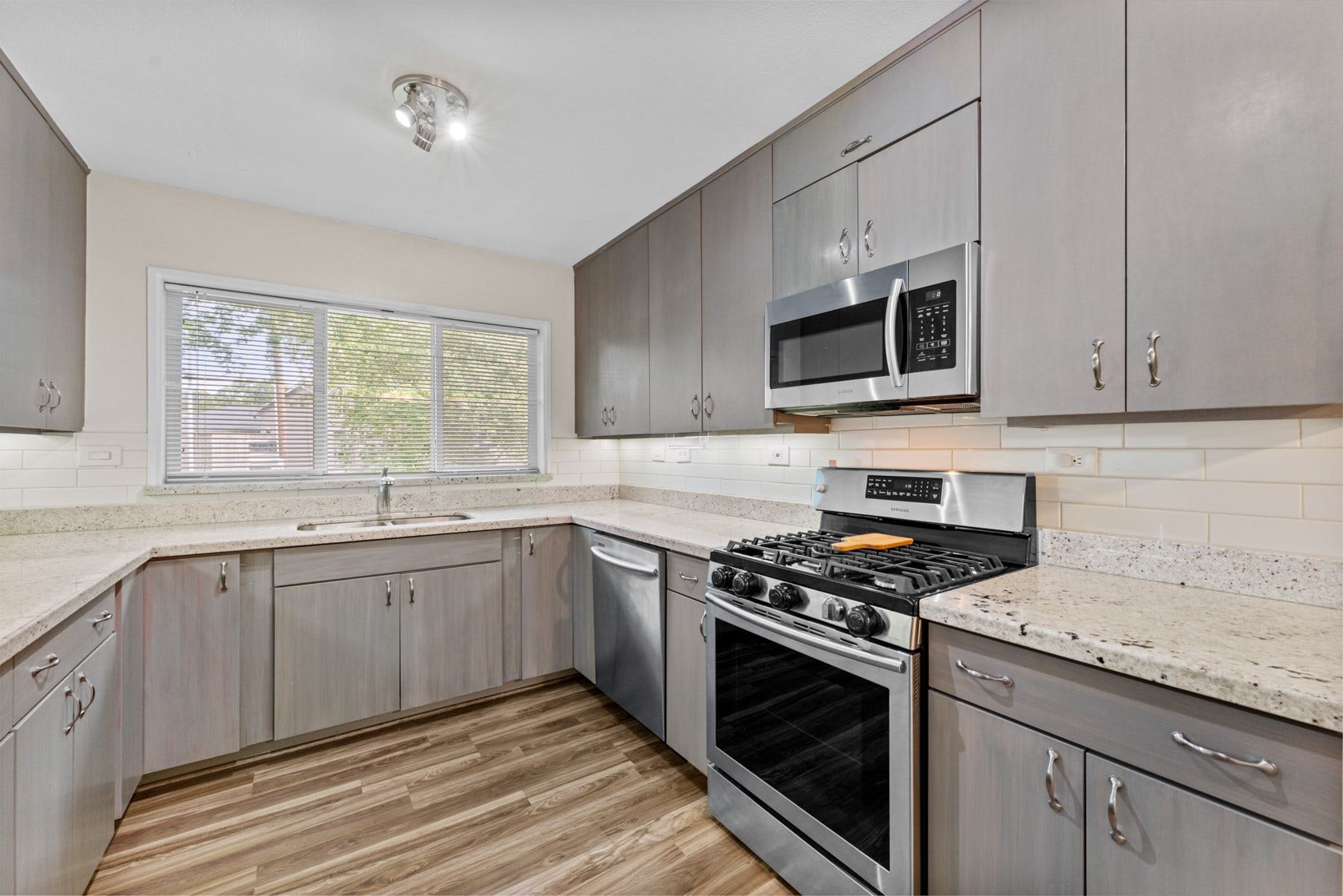 Bright kitchen with sleek cabinets and warm neutral colors.  Samsung stainless steel appliance package includes a 5 burner gas stove. Lots of cabinet storage with TWO lazy susan corner cabinets.