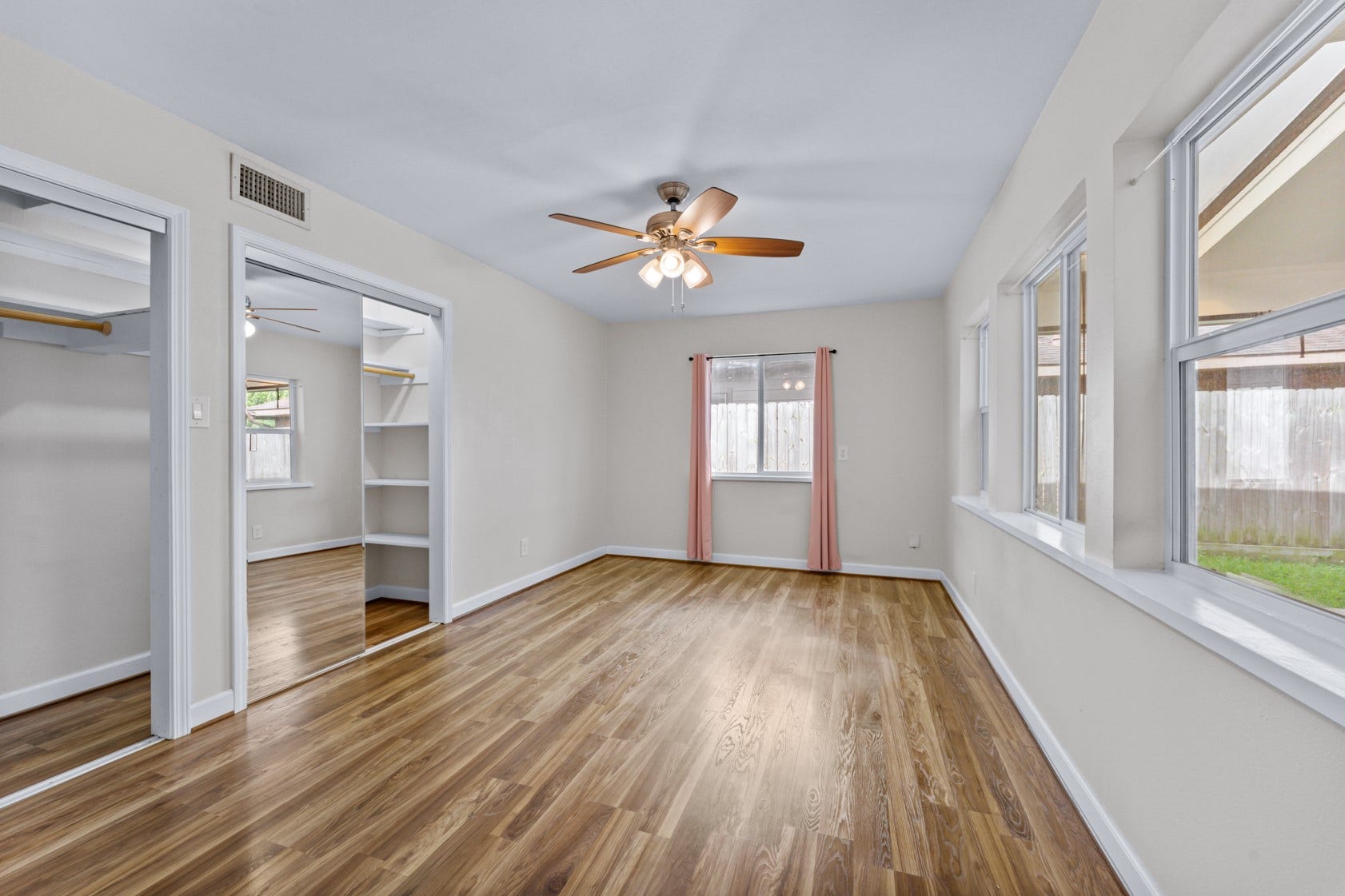 A cheery, light-filled first guest bedroom!  Extra wide closet, updated ceiling fan and flooring.