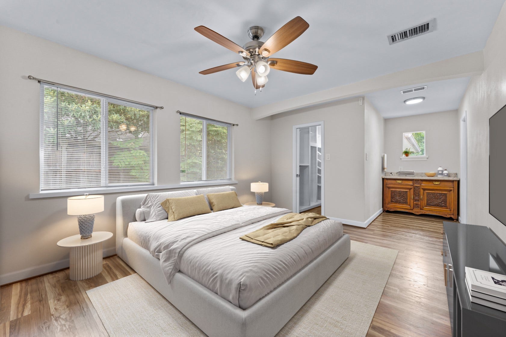 Your spacious primary suite is a true retreat located at the rear of the home! Lots of windows let sunlight stream in.  Virtually staged photo.