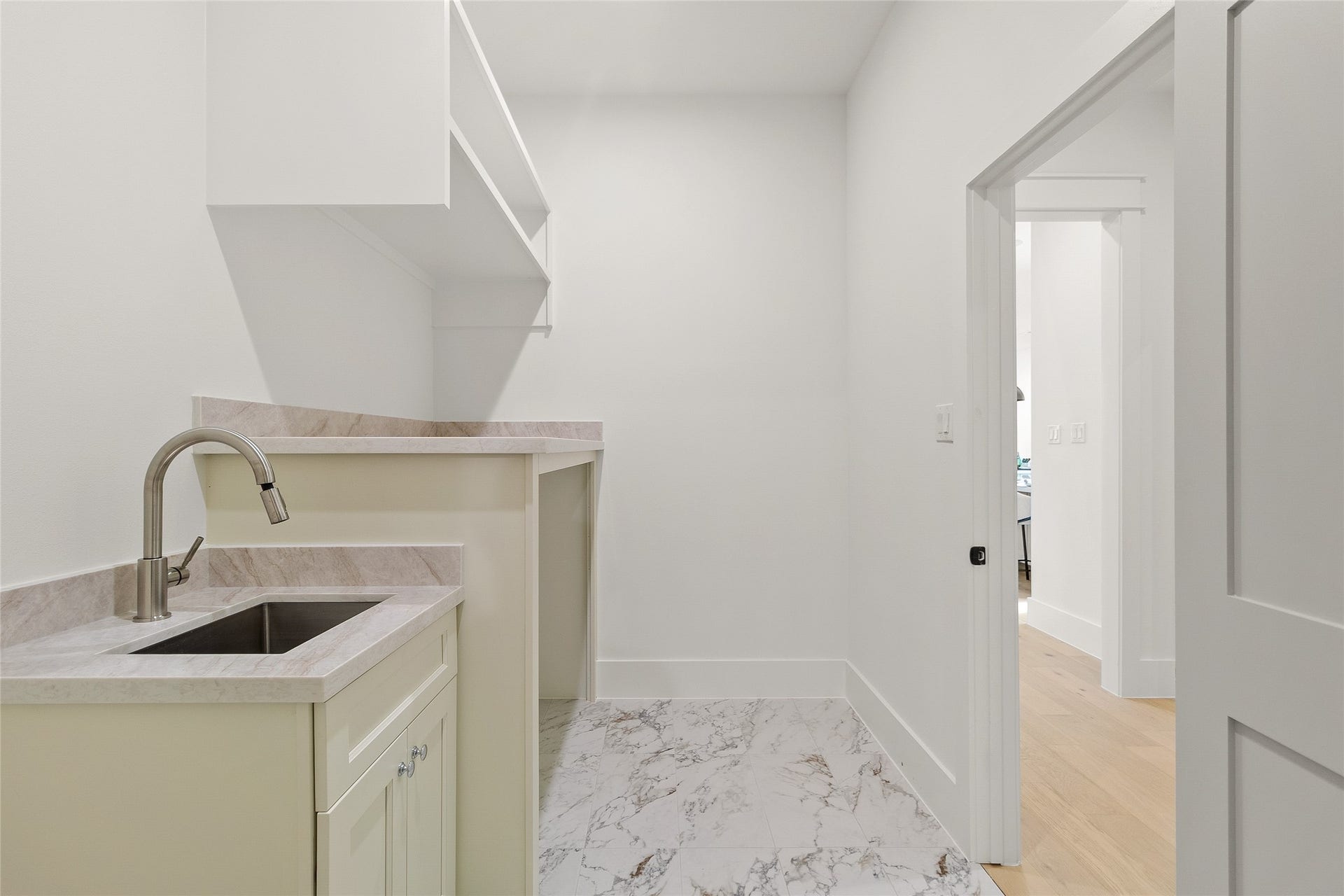 Your spacious utility room keeps laundry organized with generous counter space, a utility sink, and built-in shelving for extra storage.