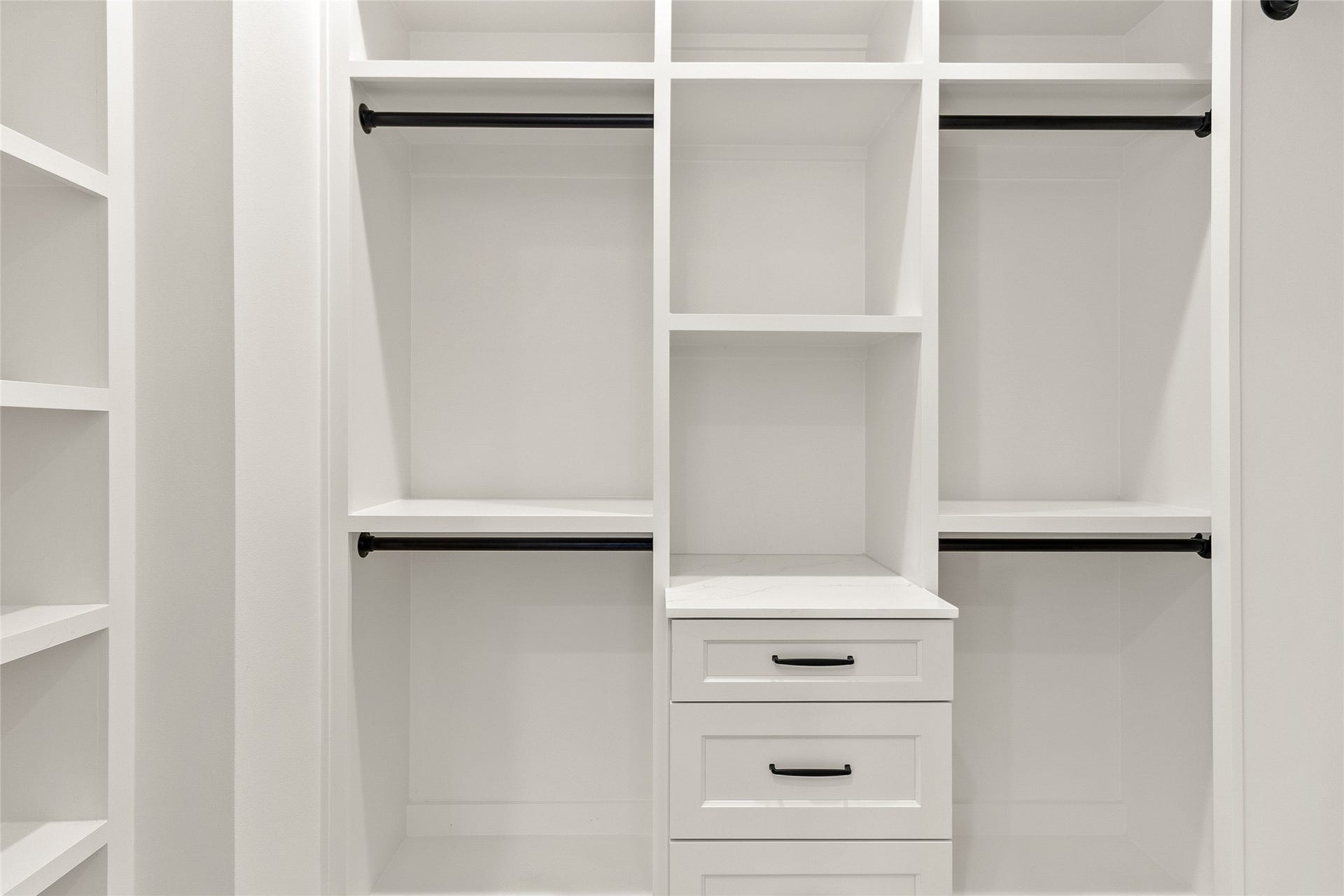 Custom built-in shelving and drawers keep every wardrobe organized, giving everything its own place.