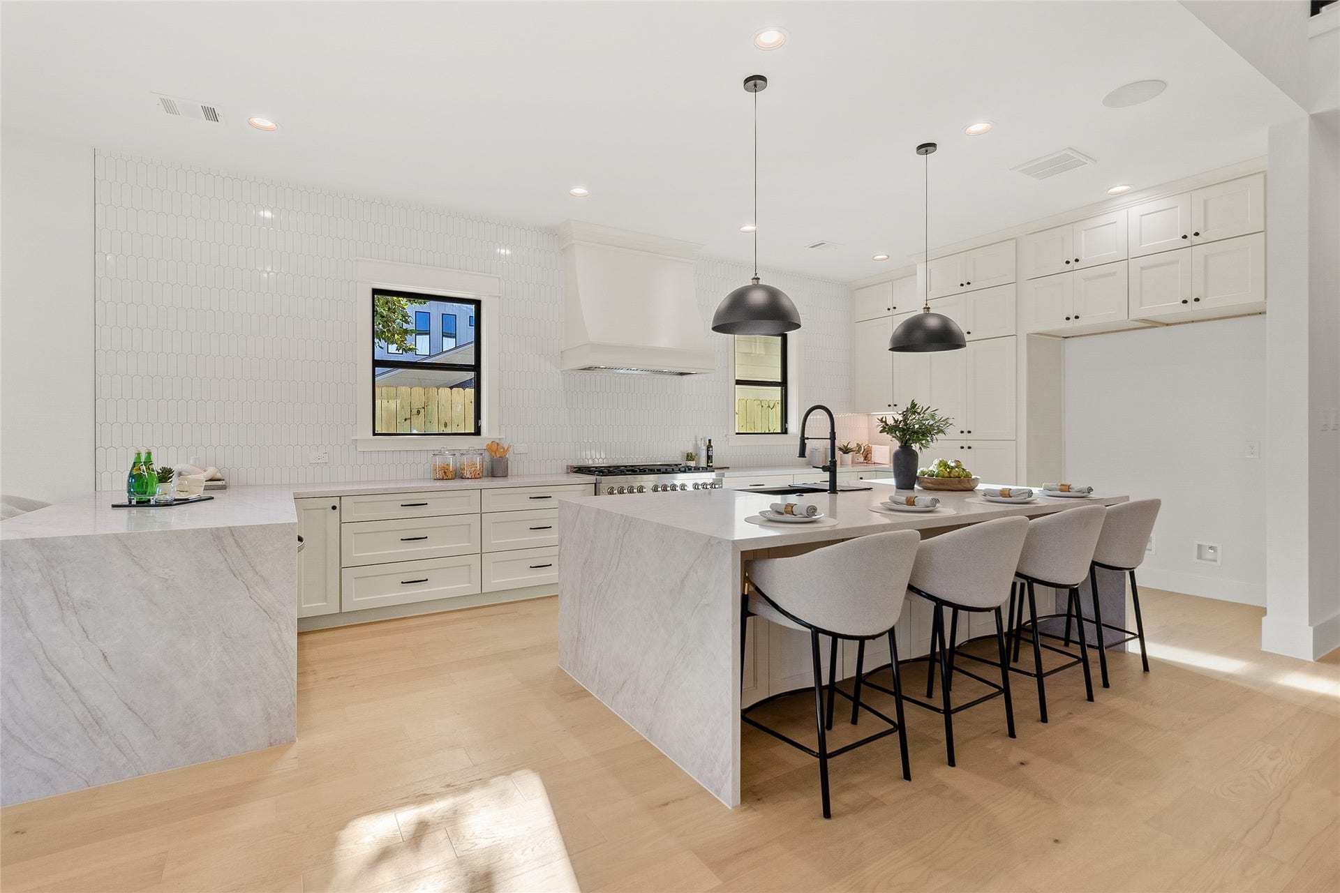 Preparing meals is a pleasure in your gourmet kitchen, where premium appliances, abundant custom cabinetry, and dual waterfall islands combine beauty with everyday function.
