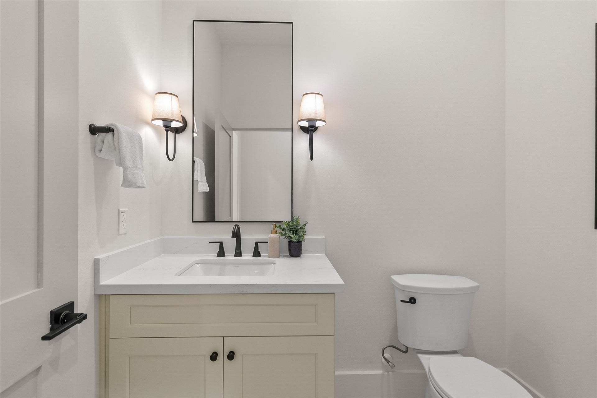 Guests enjoy a beautifully finished powder bath downstairs featuring a sleek vanity, modern fixtures, and timeless finishes.