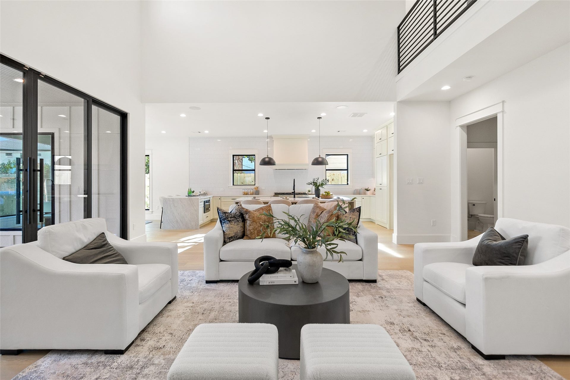 Everyday living flows effortlessly through this bright open-concept layout, where soaring ceilings, expansive windows, and seamless connections create a home that feels both spacious and welcoming.