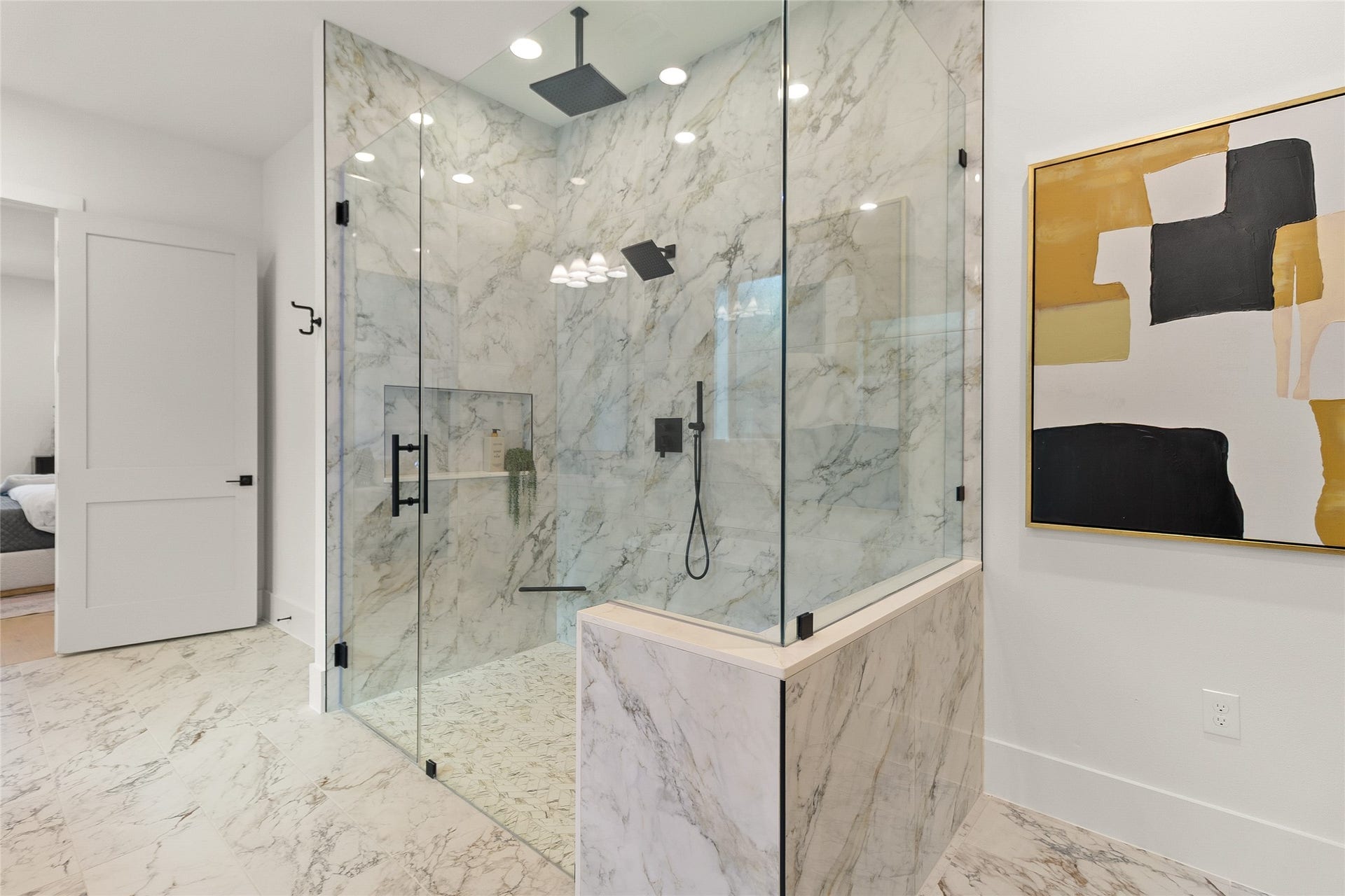 Every shower feels like a five-star experience in your expansive walk-in shower, wrapped in marble-look tile with dual rainfall showerheads and sleek frameless glass.