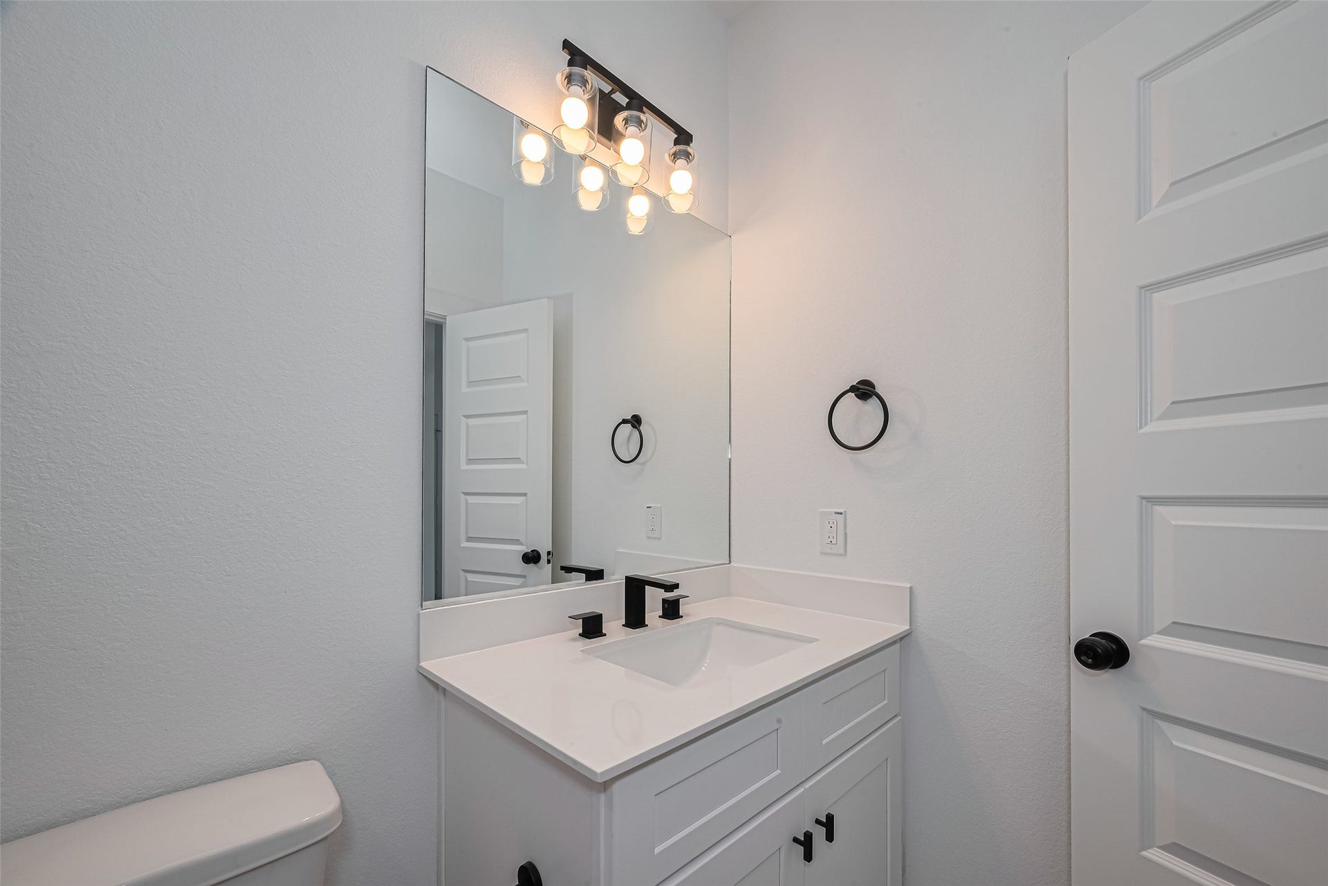 1350 W 24th Street, Houston, TX 77008 Bathroom vanity with a modern mirror, stylish lighting, and clean finishes.