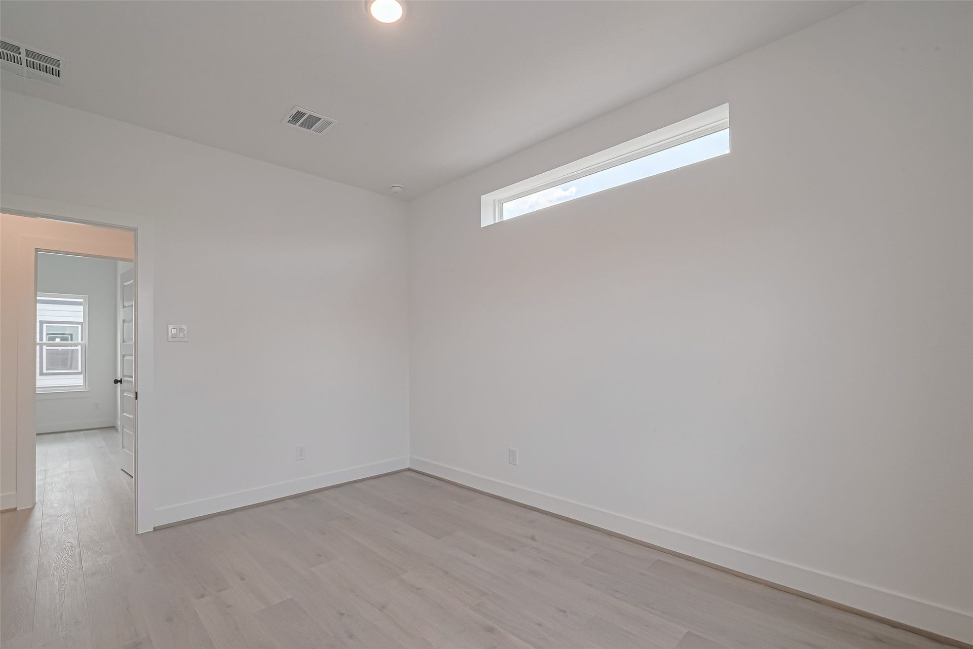 1350 W 24th Street, Houston, TX 77008 Bright bedroom with a high window allowing natural light while maintaining privacy.